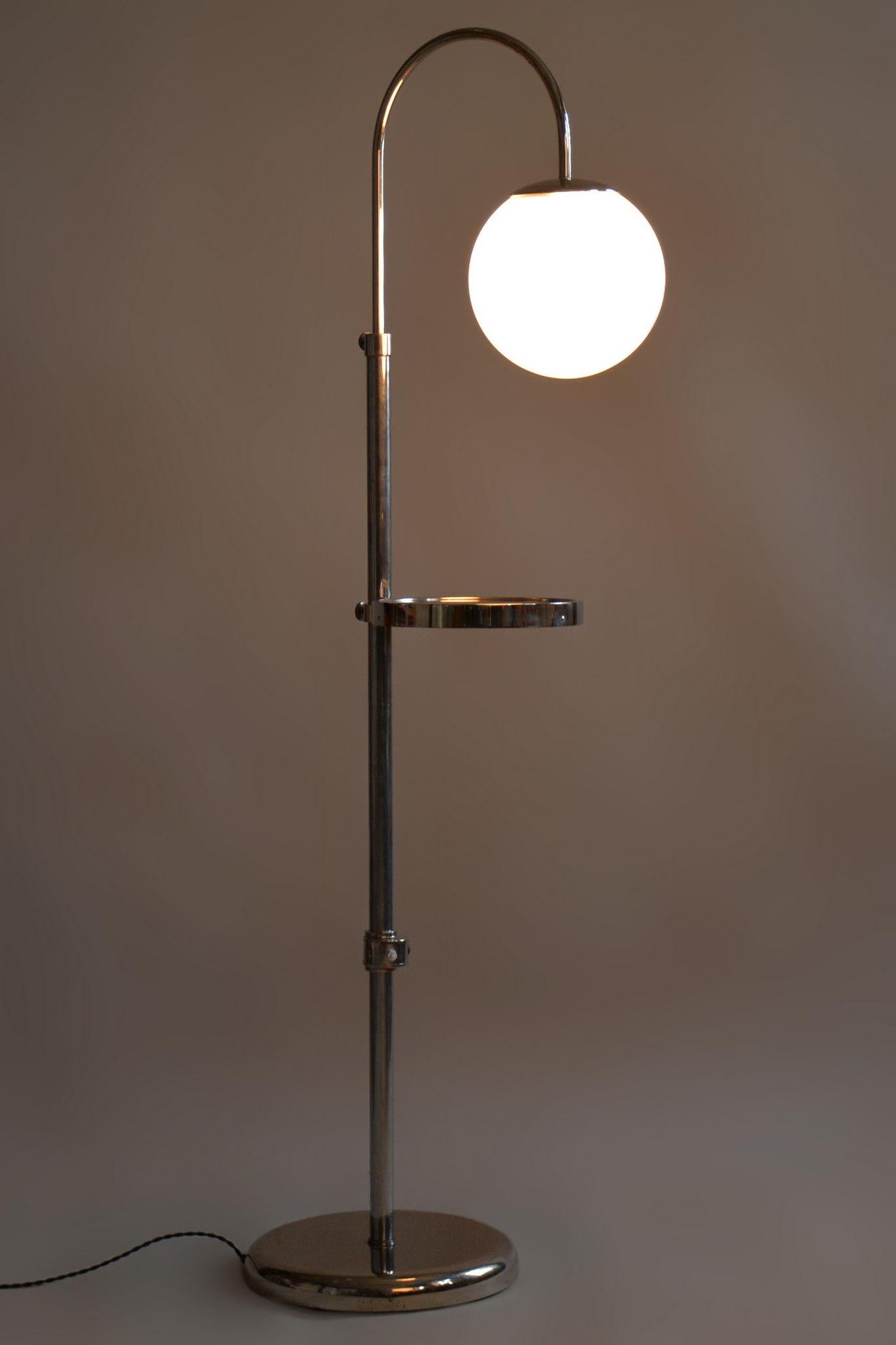 Restored Bauhaus floor lamp

Origin: Czechia 
Period: 1930-1939
Material: Chrome-plated steel, milk glass

Adjustable lamp height (167 - 185 cm).

Adjustable shelf height.

The chrome parts have been cleaned and professionally restored. 			

This