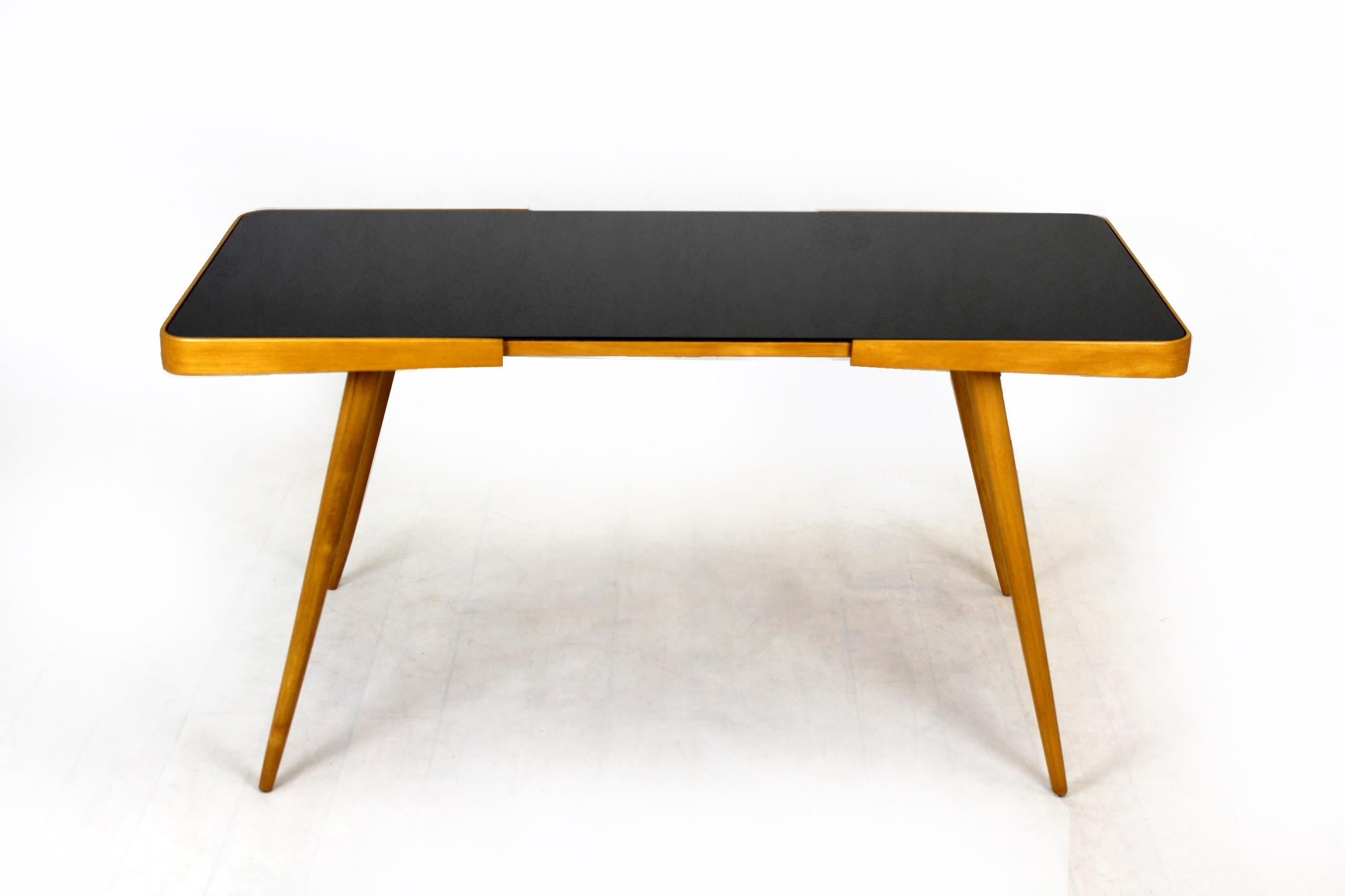 
Coffee table with black glass top. Designed by Jiri Jiroutek and produced in the 1960s by Cesky Nabytek. The table has been completely restored, lacquered wood, satin finished, new glass top.