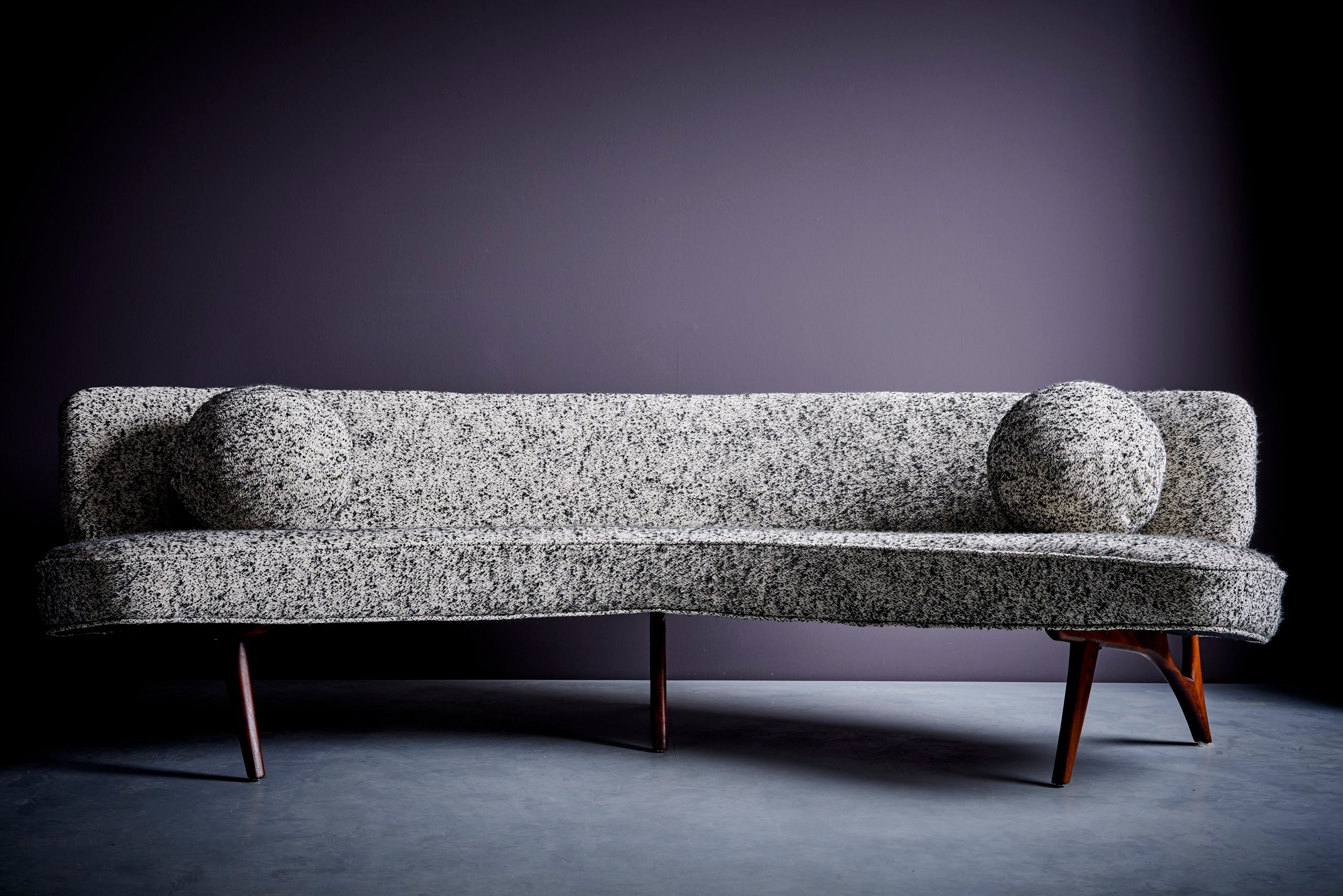 Curved 1950s sofa with sculptural legs in the manner of Vladimir Kagan. Purchased from the original owners, who bought the sofa from an interiors gallery in a villa in Hamburg, Germany.  The sofa has been restored with new upholstery. 
