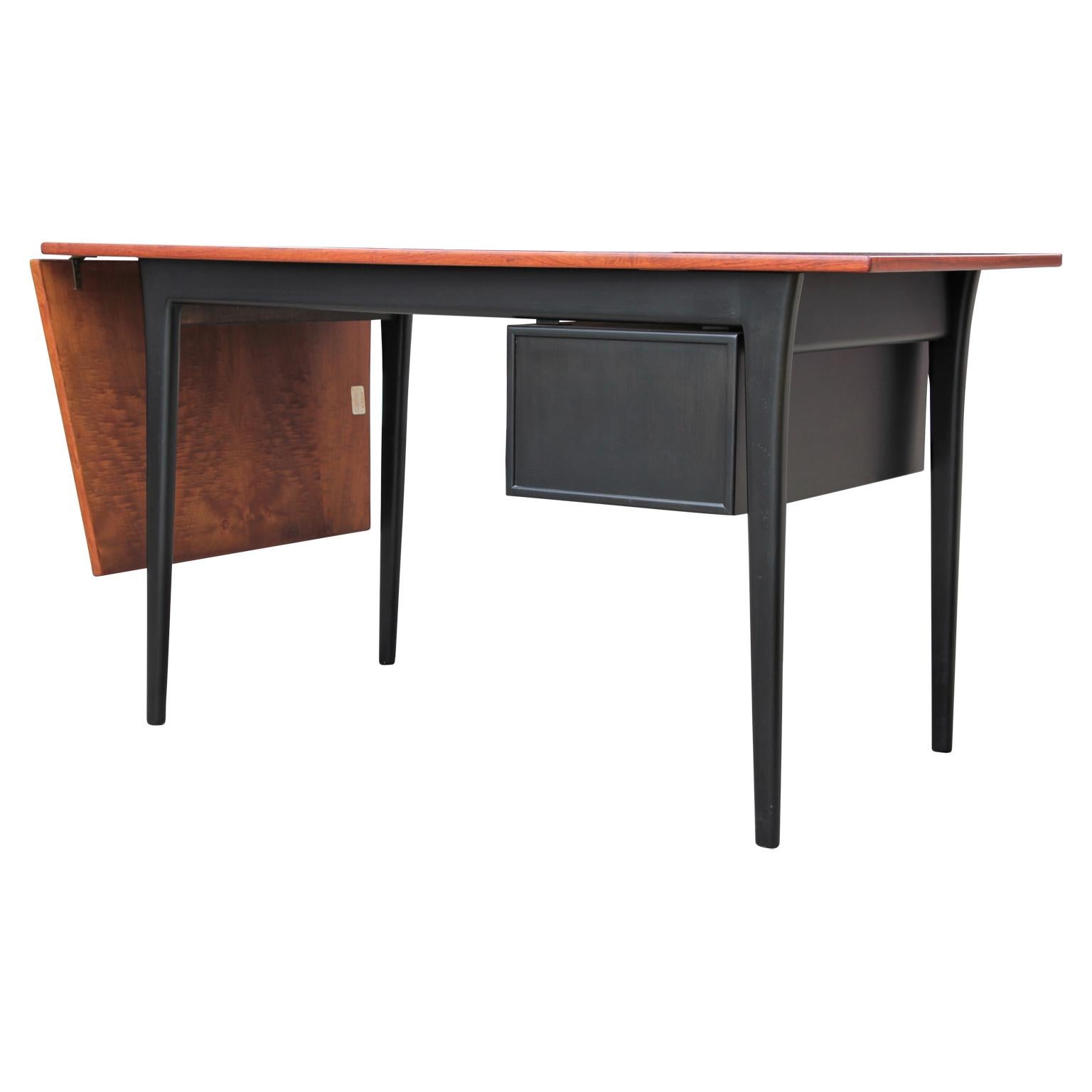 Restored Danish rosewood drop leaf desk by Arne Vodder for Sibast. Circa 1960s. Made in Denmark. Black stain on the rest of the writing desk.
Measures: Width with leaf down: 49.875 in.
Depth at widest point: 31.375 in.
Depth at thinnest point: 26