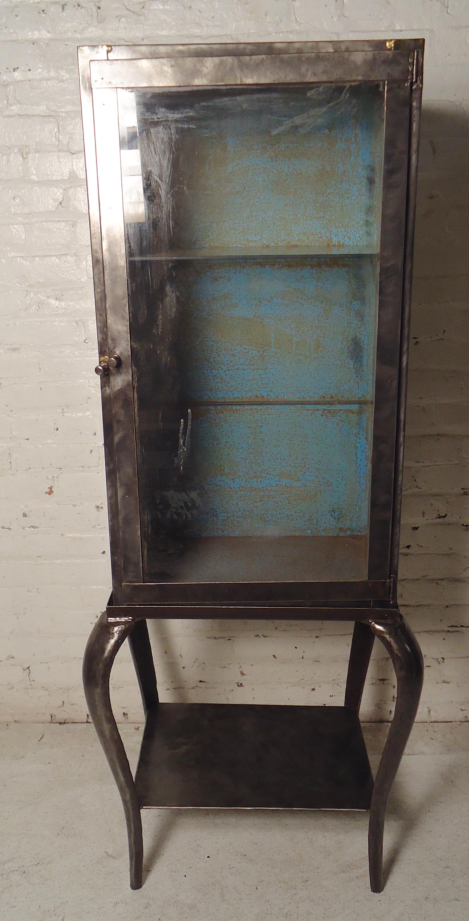 Two-piece metal cabinet with glass front top and sturdy metal base. Removable glass shelf and rustic blue inside.

(Please confirm item location - NY or NJ - with dealer).
 