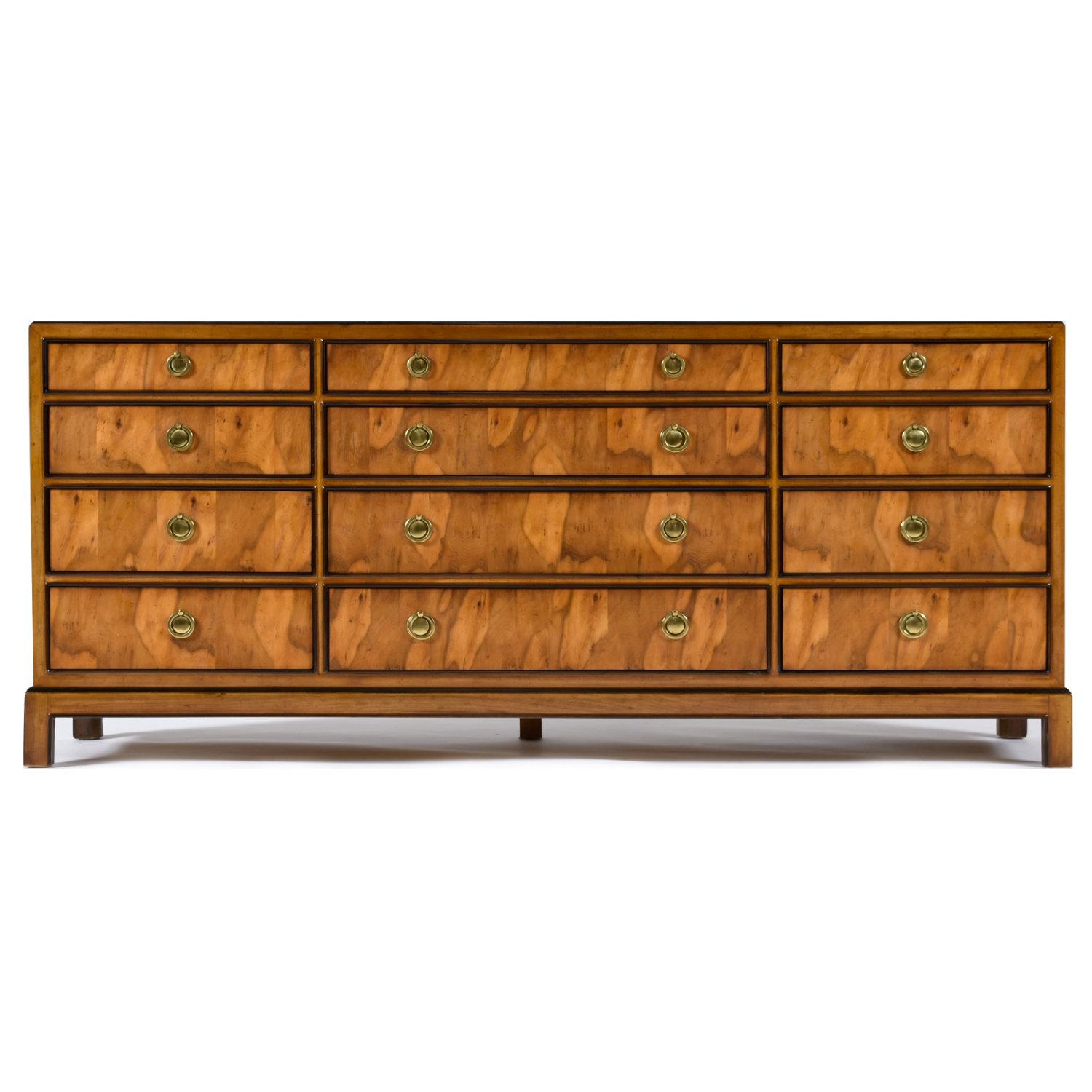 Beautifully figured burl wood Drexel Avenues campaign dresser. Offered by Drexel from their “Avenues” line of interior furnishings. The dresser is as functional as it is beautiful. There’s is no want for storage with this ample twelve drawer