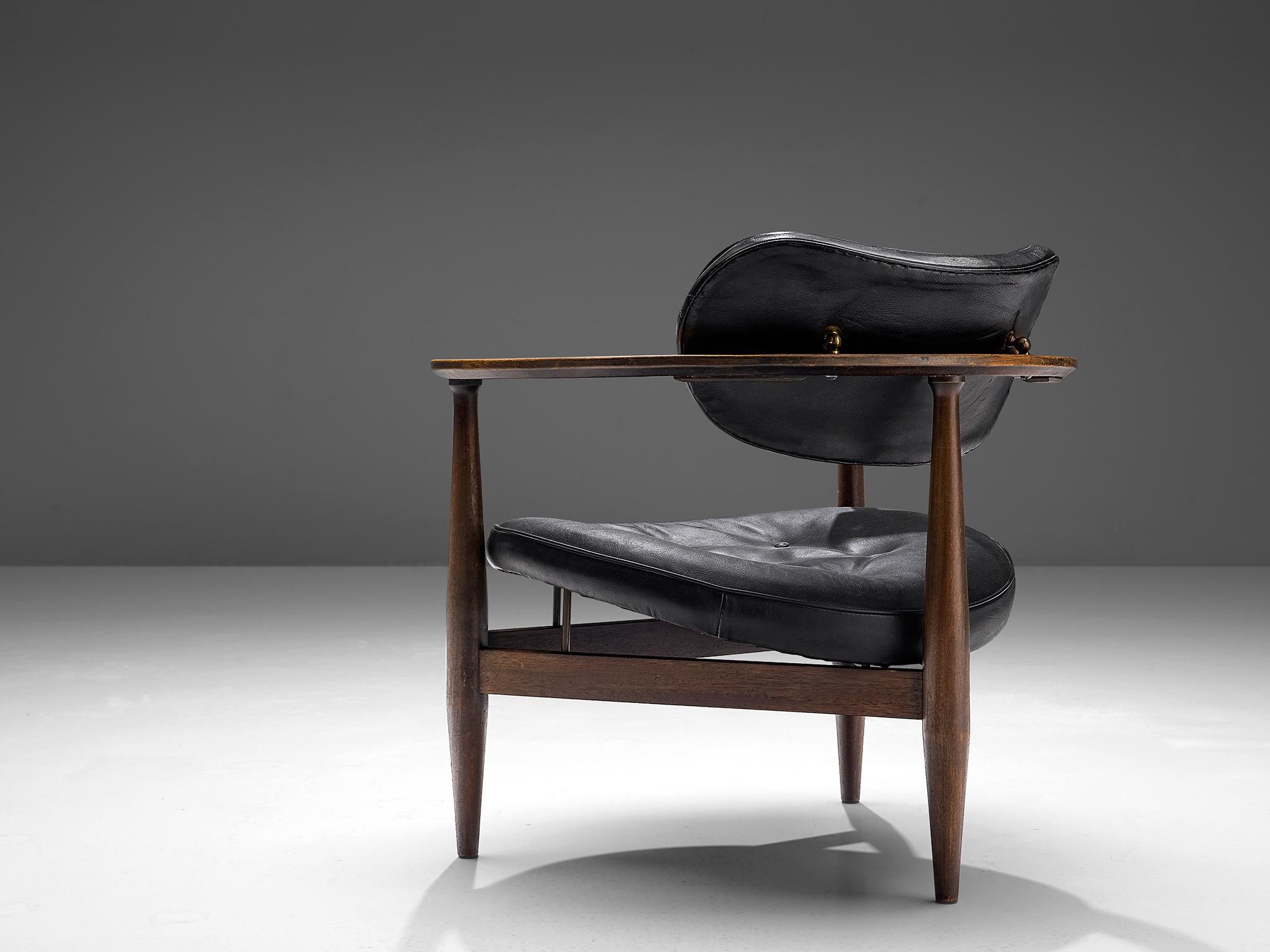 Dutch lounge chair, black leather, wood, the Netherlands, 1960s

This sculptural lounge chair has a butterfly shaped back and a round seat. The frame is softly shaped and holds elegant details such as the tiny wooden pins underneath the seat. Other
