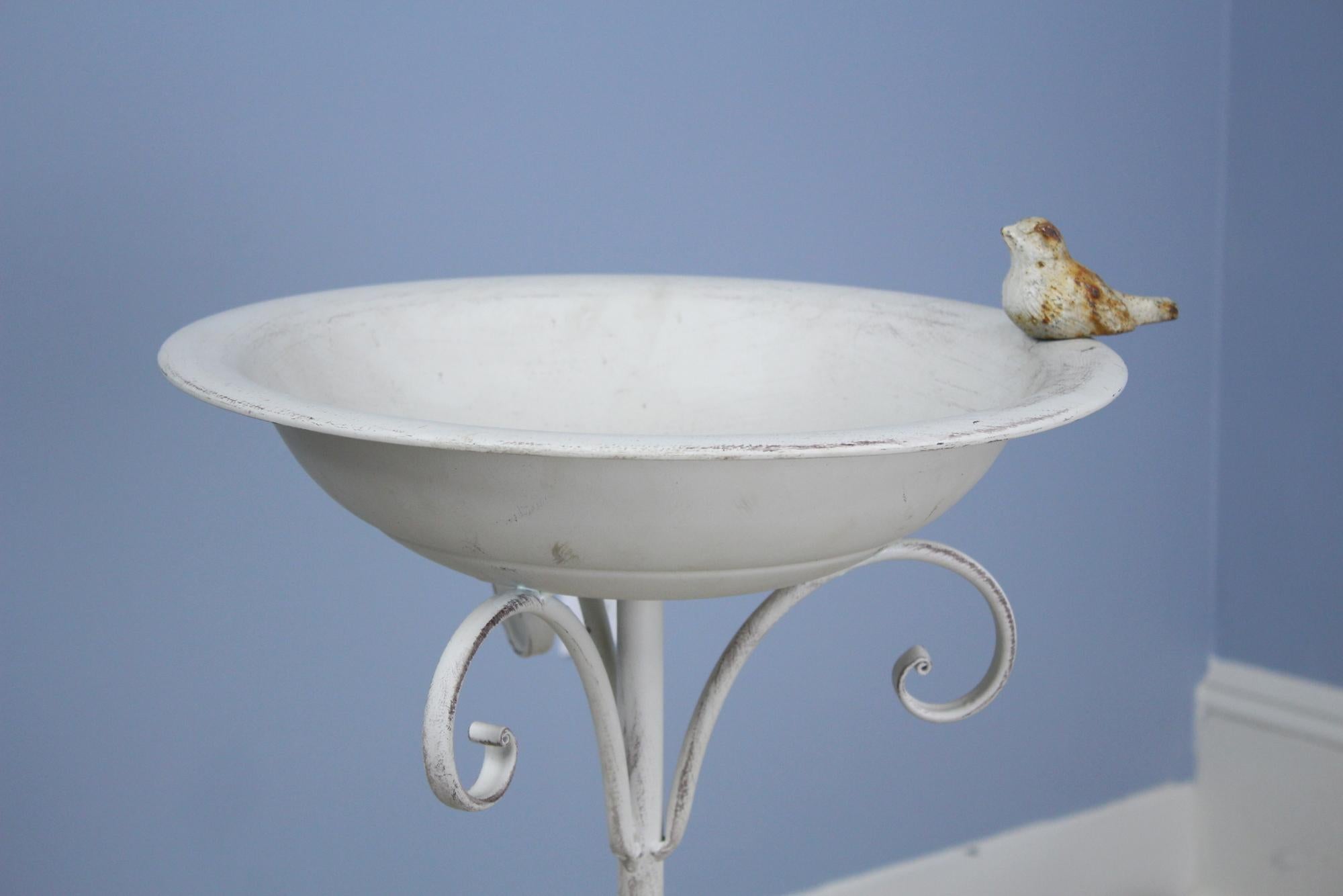 A delicate metal bird bath, restored paint and faux distressed. The small bird feature on the side, with fully articulated face and feathers, fills this piece with charm!
