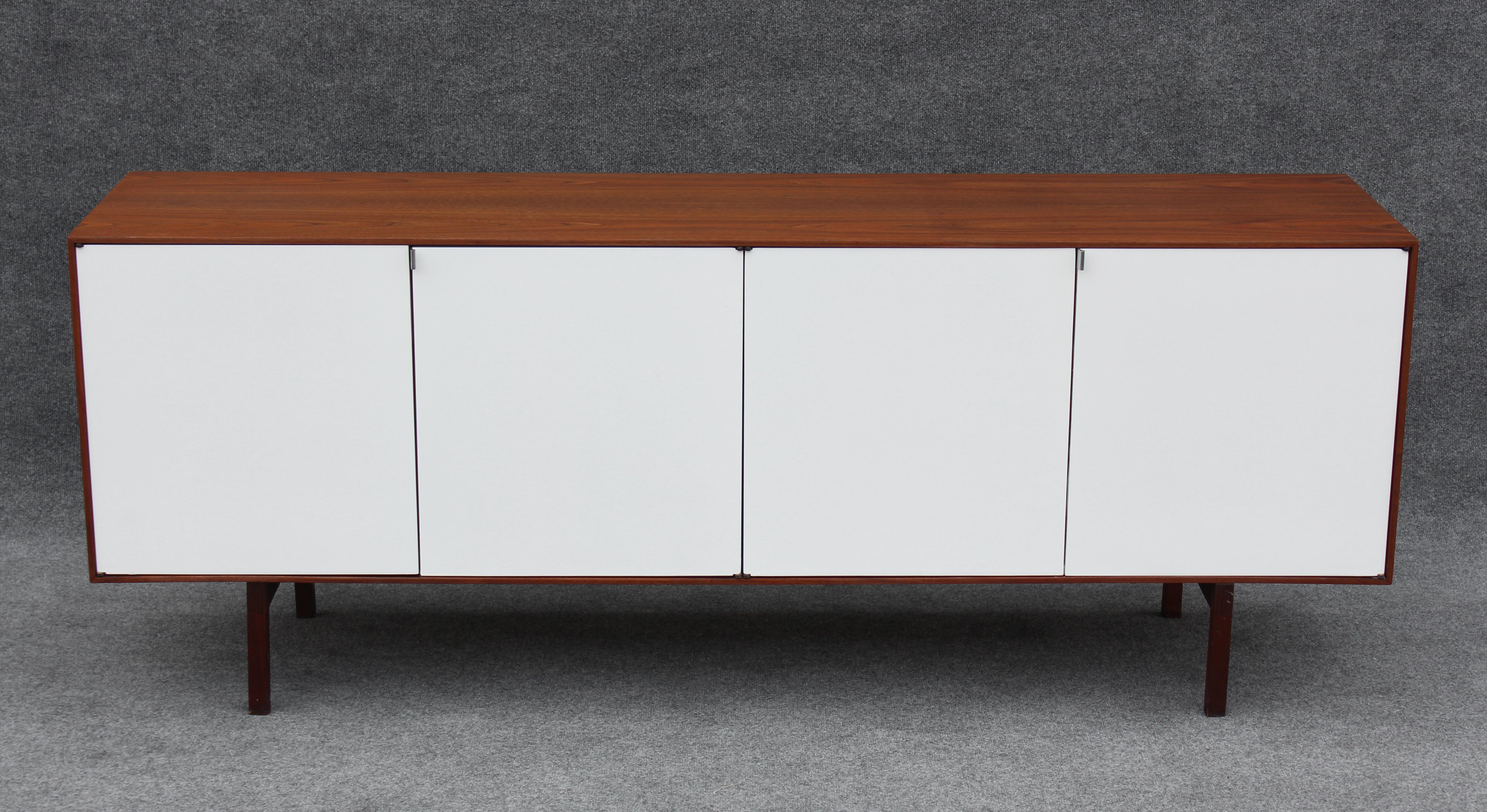 This iconic cabinet was designed in the 1960s by Florence Knoll and manufactured by Knoll International for sale in the heart of New York City on Park Avenue. Built of a finely grained walnut, its contrast with its white doors makes for a very