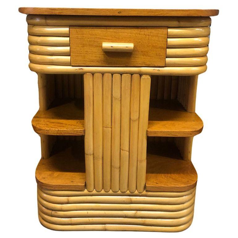 This beautifully restored rattan three-tier rattan end table was inspired by the works of Paul Frankl blending style with vintage charm and modern comfort. It features open sides, rich mahogany wood tops and drawers, and a captivating floating