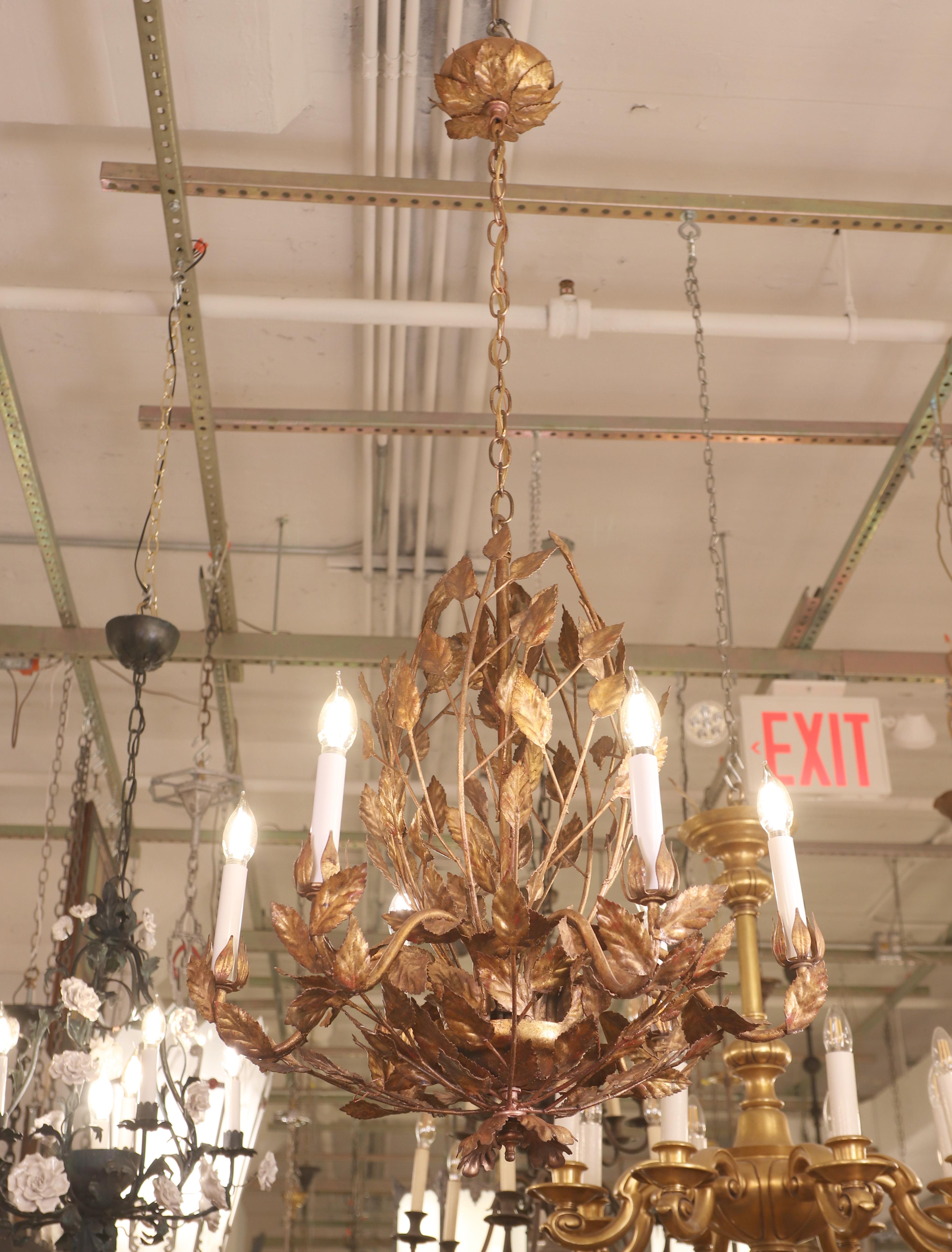 Tole style foliate 6 arm chandelier with an ornamental flower motif canopy. This light requires six candelabra light bulbs. This light is wired and ready to ship. One available. Cleaned and restored. Please note, this item is located in one of our