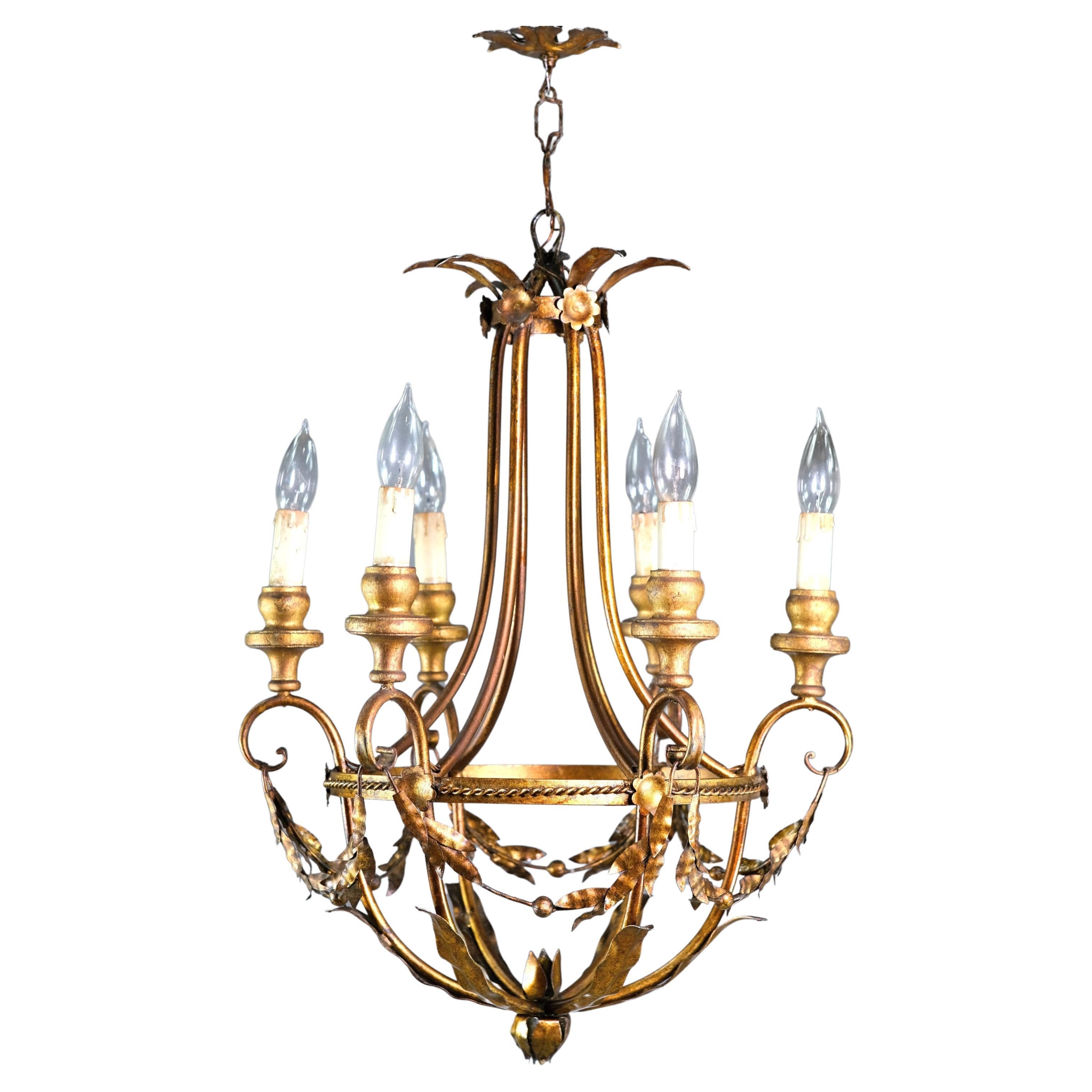 20th century chandelier from Italy. Made from gold gilt steel and wood. Features 6 arms and dripping with crystals. Floral, foliate design accents. This can be seen at our 400 Gilligan St location in Scranton, PA.