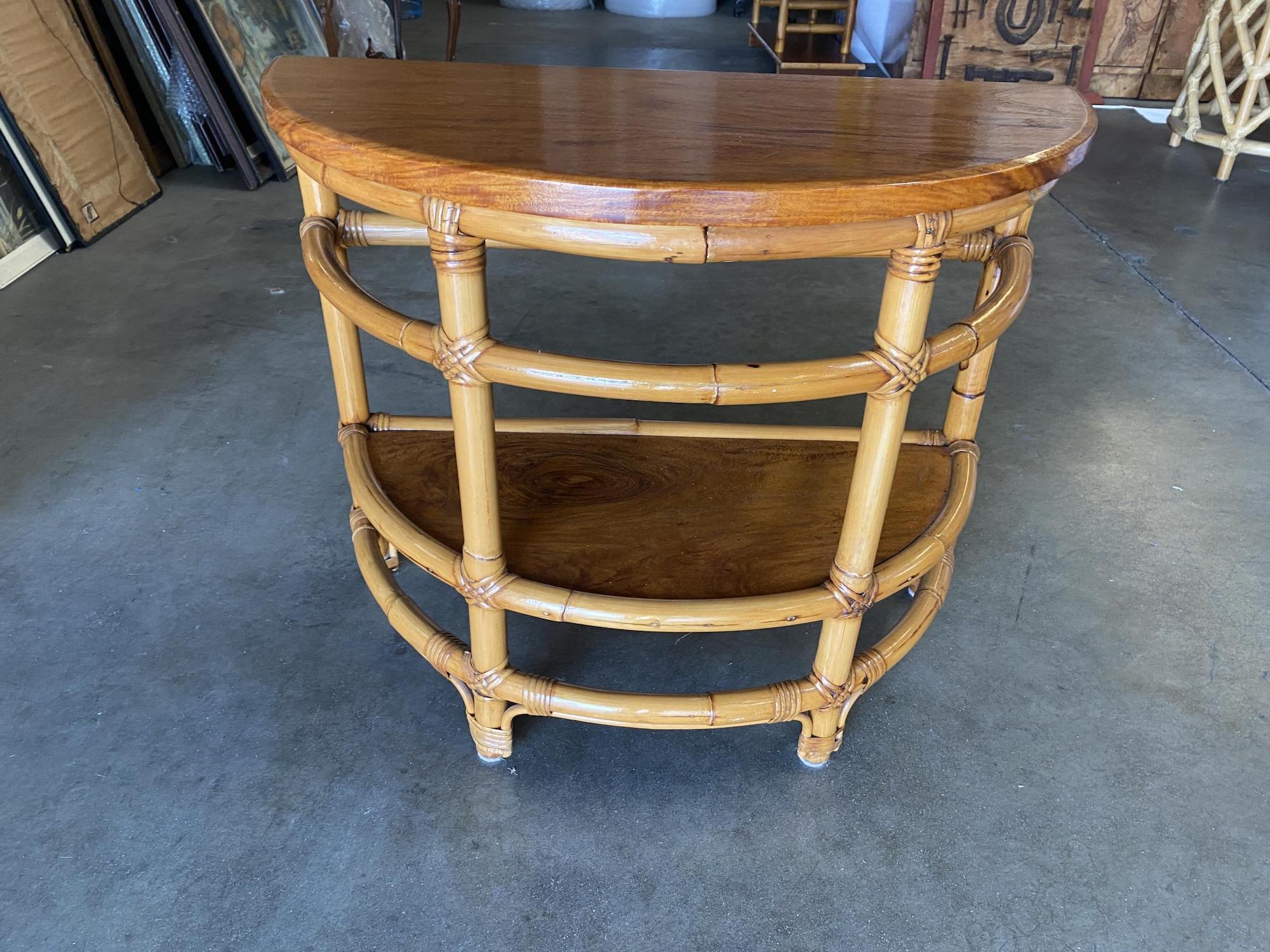 Vintage 1940s two-tier rattan side table featuring stylized single strand legs, ladder sides and beautiful half round mahogany tops.
 
Tropical Sun Rattan was started in 1934 at 117 West Colorado Blvd in Pasadena. By 1938 we had showrooms in the