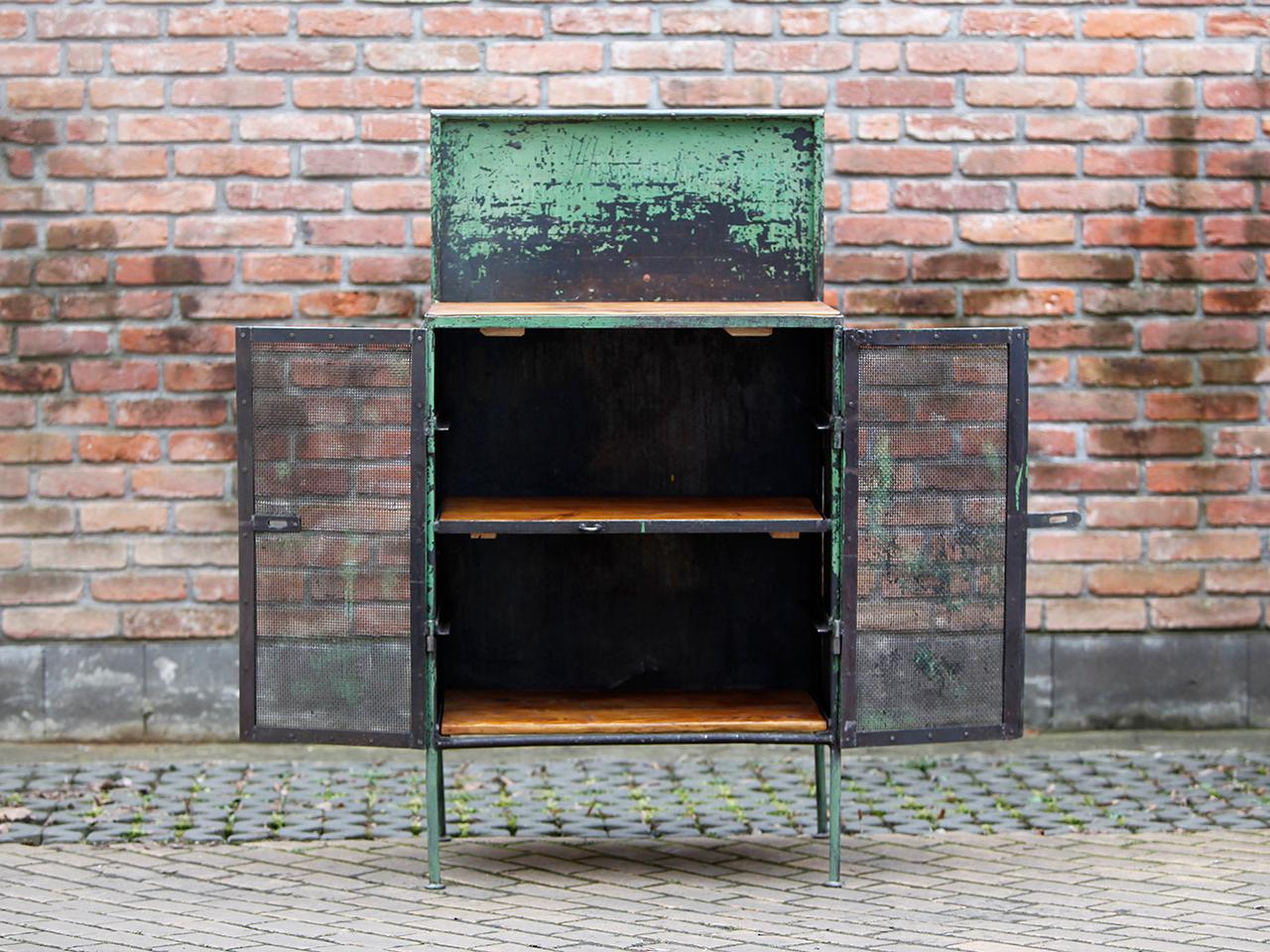 This painted steel sheet cabinet comes from a factory hall of the Czech company Tesla in Roznov. It was completely cleaned and restored. Good vintage condition with patina.