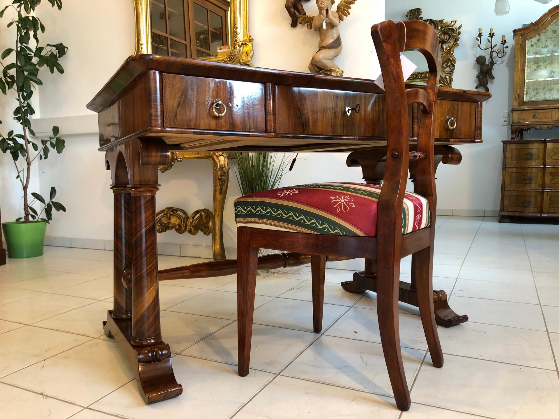 Original desk from the time of the Biedermeier circa 1845 designed by Josef Danhauser, Vienna.
A beautiful restored desk with stunning column feet and a rootwood or burl writing surface with an inlayed new red leather panel.
This desk is an