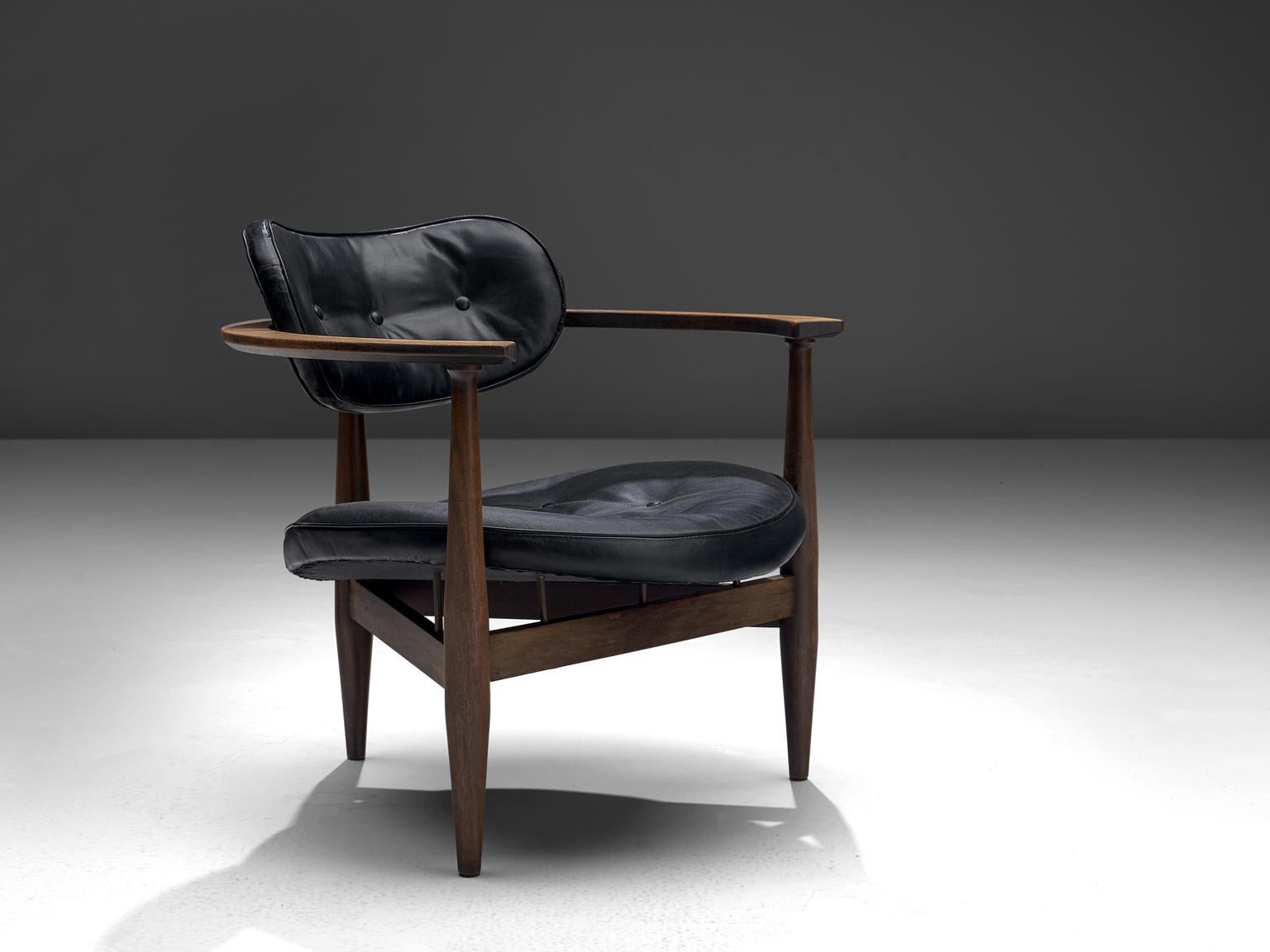 Kor Aldershof lounge chair, black leather, wood, the Netherlands, 1960s.

This sculptural lounge chair has a butterfly shaped back and a round seat. The frame is softly shaped and holds elegant details such as the tiny wooden pins underneath the