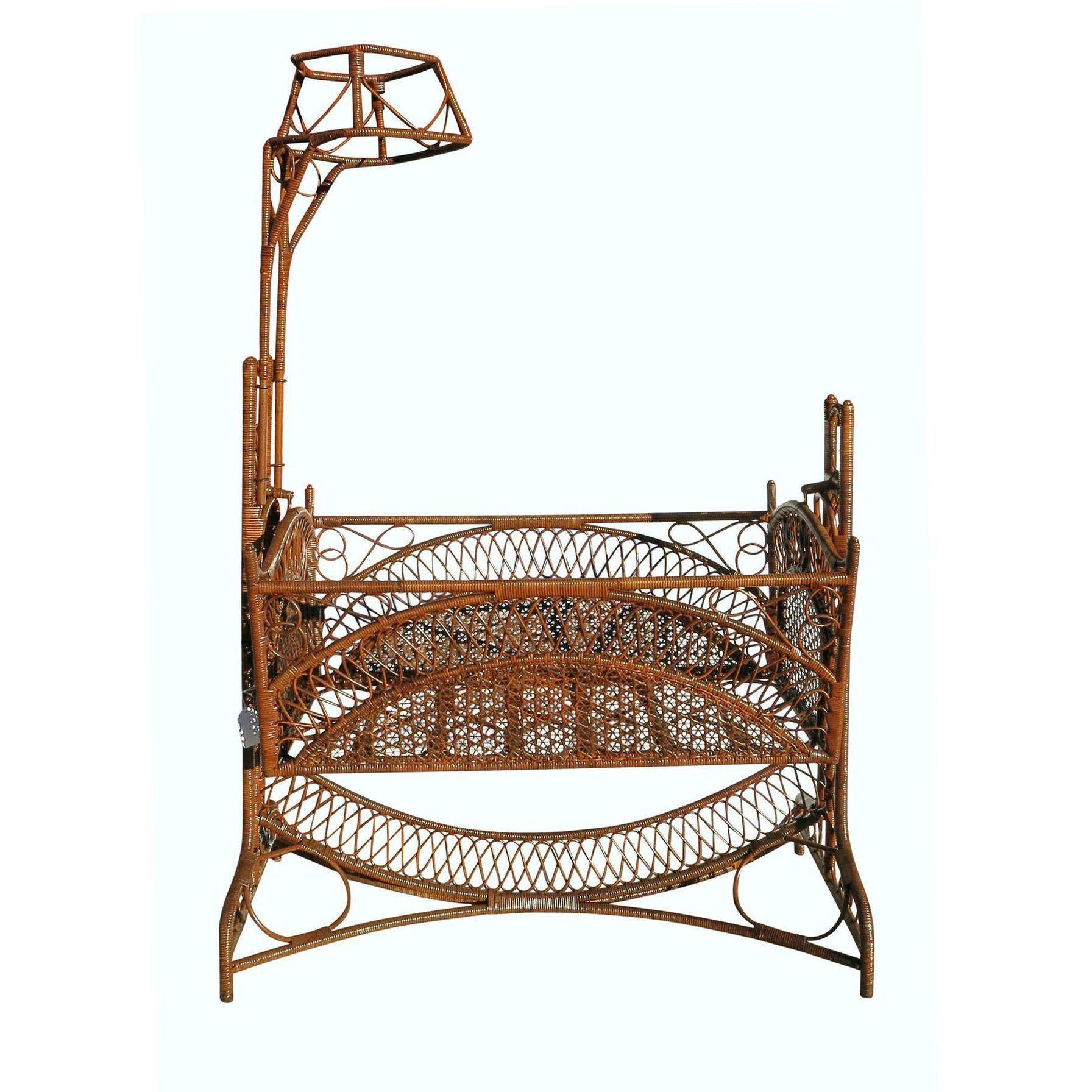 This dark-stained Victorian wicker, rattan, and bamboo cradle possess intricate patterns that give it an almost Gothic quality. An array of symmetrical reed arches and seamless striping crisscrossing designs are worked into the entire piece. The