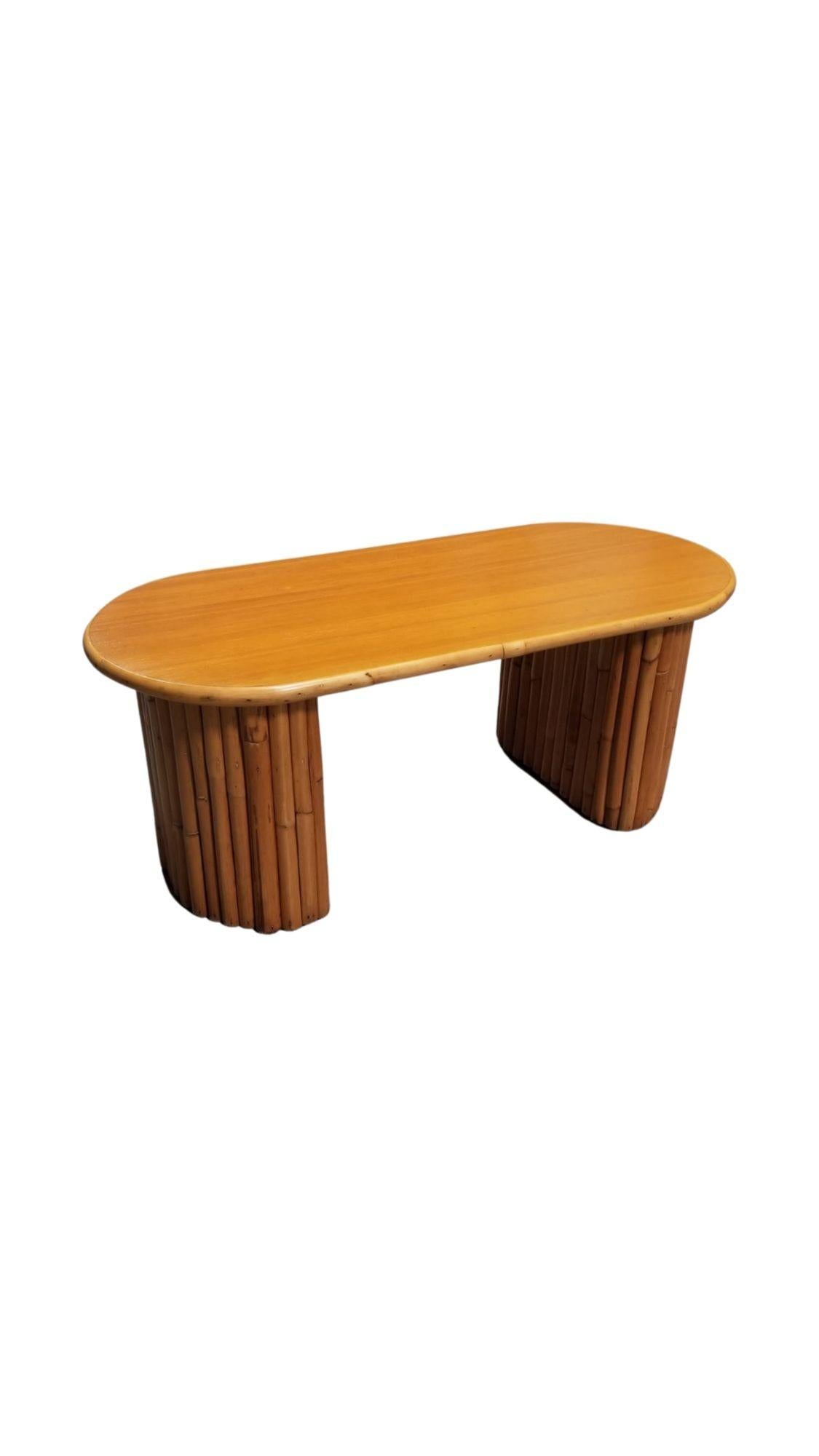 Cette table basse en rotin du milieu du siècle, inspirée par Paul Frankl et magnifiquement restaurée, possède des pieds en rotin empilés verticalement en demi-lune et un plateau en acajou massif. Son design s'inspire des meubles en rotin du designer