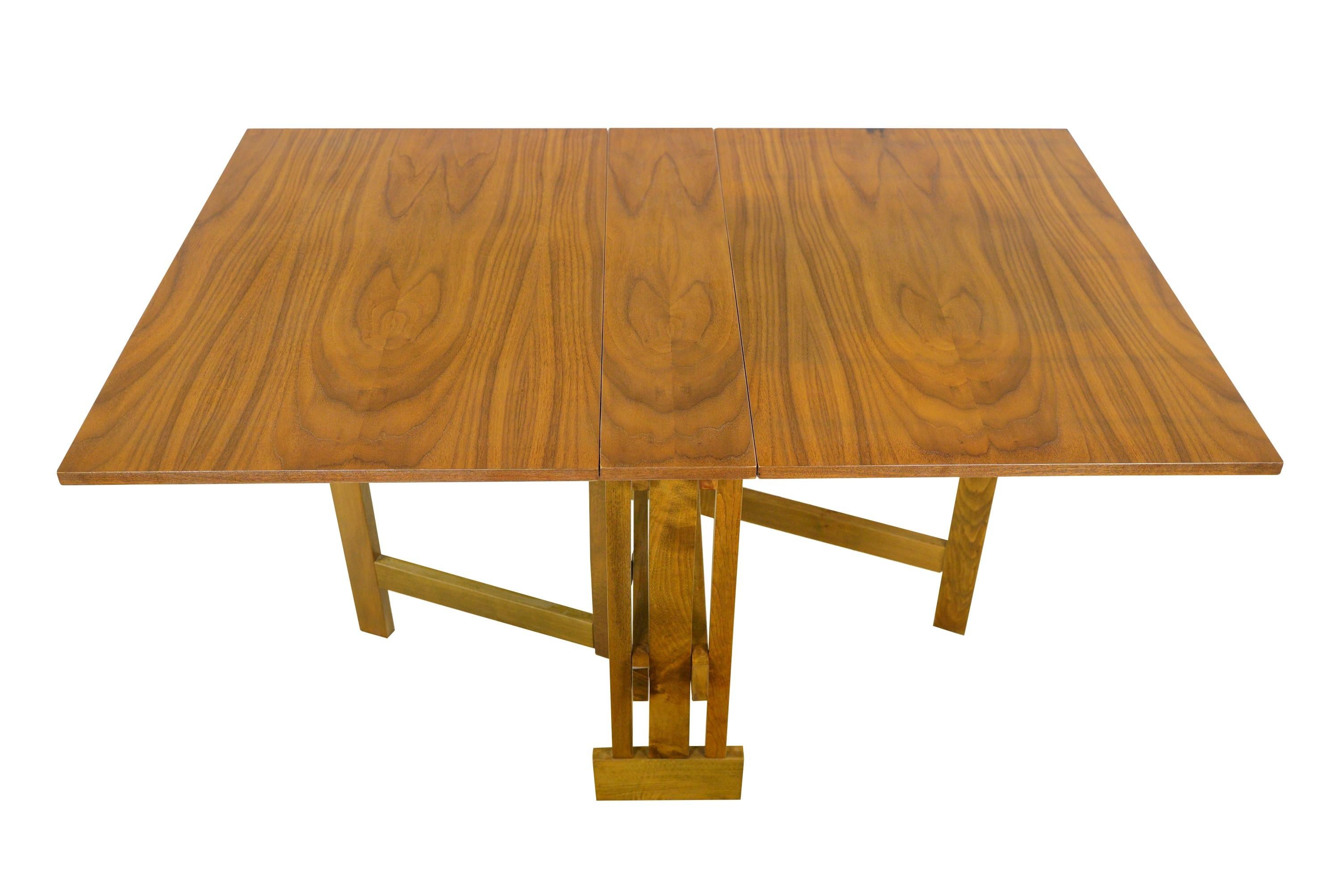 This restored maple drop leaf dining table, ingeniously designed with foldable leaves, allows for versatile seating arrangements and efficient space utilization. Its refinishing enhances its aesthetic appeal and functionality, making it an ideal