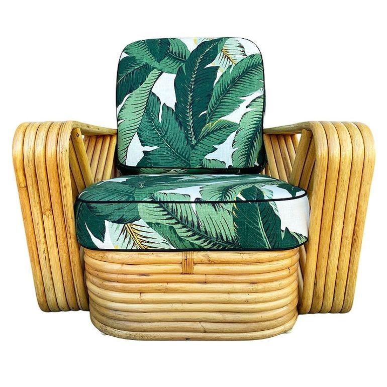 This beautifully restored mid-century six-strand rattan lounge chair features square pretzel arms and a classic stacked base. Each chair blends style and vintage charm with modern comfort. Made of steam-bent rattan poles, the sofa features