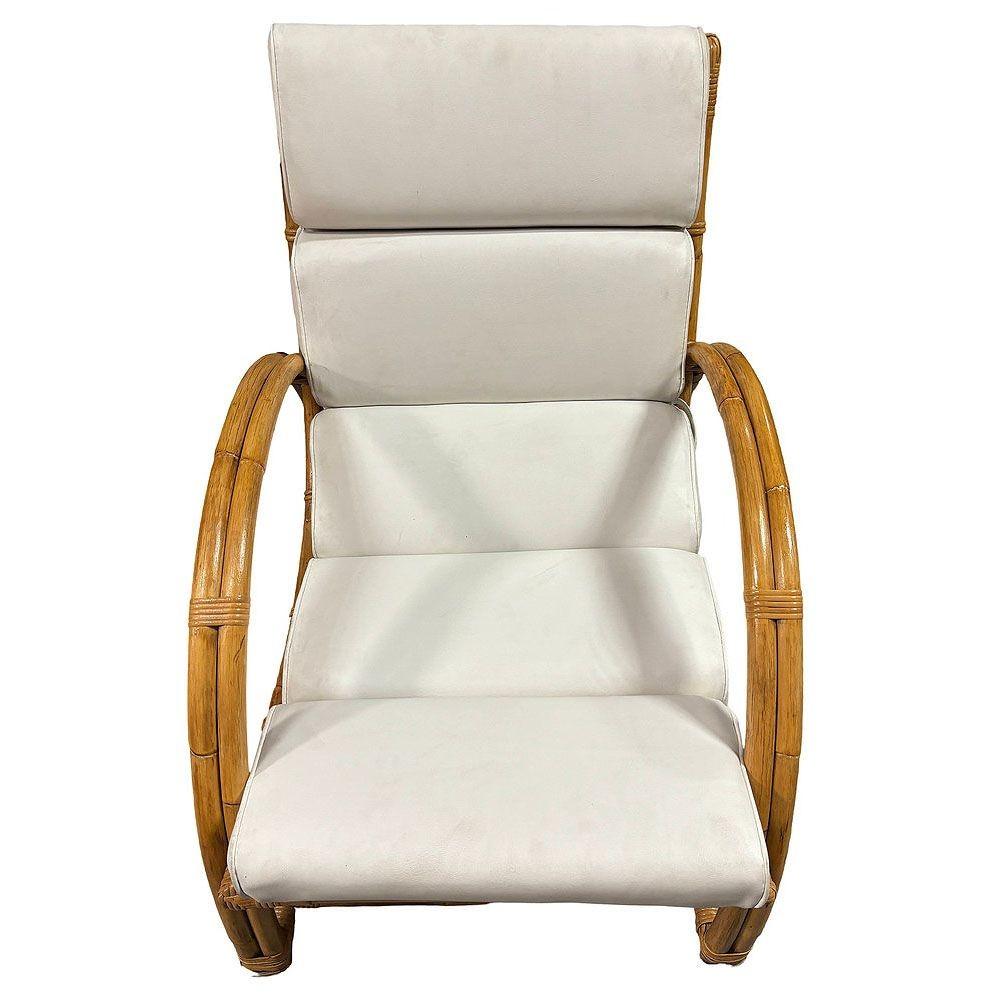 La original tumbona de ratán inspirada en Paul Frankl presenta un diseño de brazos en forma de media luna de doble filamento con un asiento de ratán curvado en forma de bastón. La silla presenta elegantes envolturas de mimbre a lo largo de las