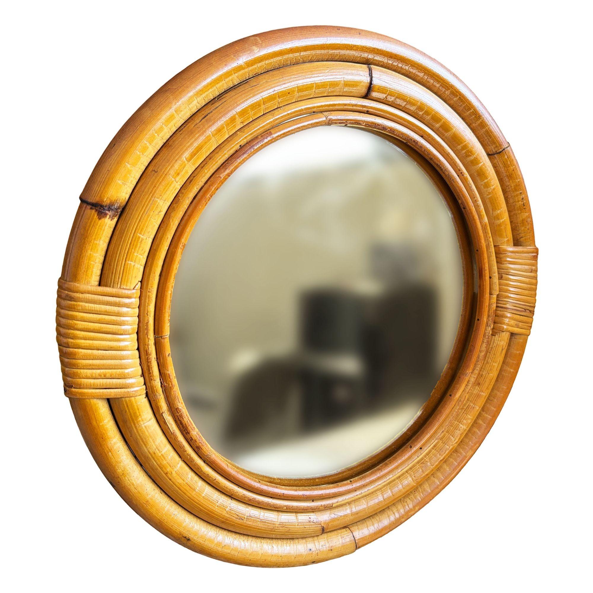 Ce miroir rond en rotin du milieu du siècle, magnifiquement restauré, présente un cadre en rotin à quatre brins avec une bordure intérieure en rotin à bâtons. Le miroir allie le style et le charme vintage au confort moderne. Il a été méticuleusement