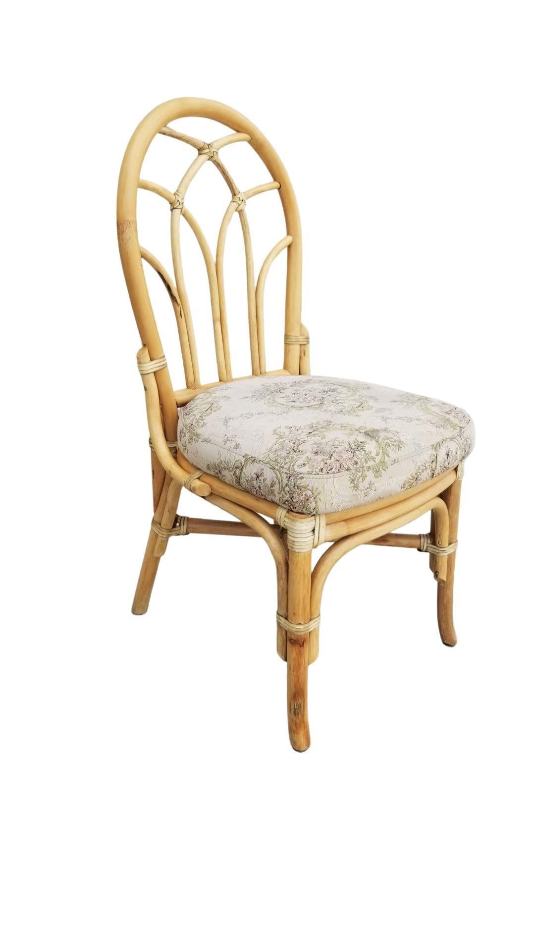 Set of 9 rattan dining chairs with an organic floral-like style back design. The seats are upholstered in a floral French provincial-style fabric.
All rattan, bamboo, and wicker furniture has been painstakingly refurbished to the highest standards