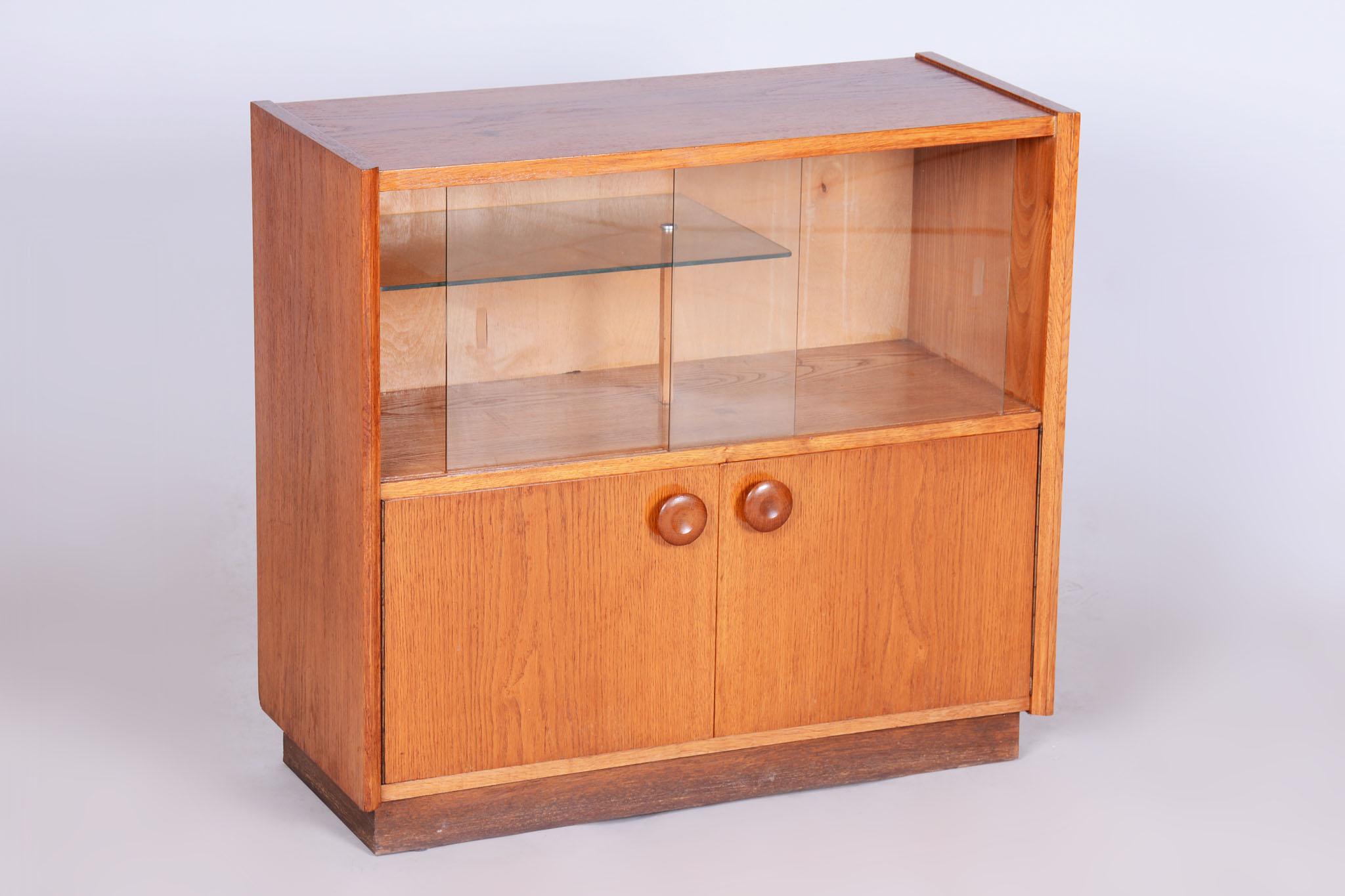 Questa libreria della seconda metà del XX secolo proviene dalla Cecoslovacchia. È stata completamente restaurata e dispone di porte scorrevoli in vetro.

Il materiale è costituito da rovere massiccio e impiallacciatura di rovere. Il produttore è la