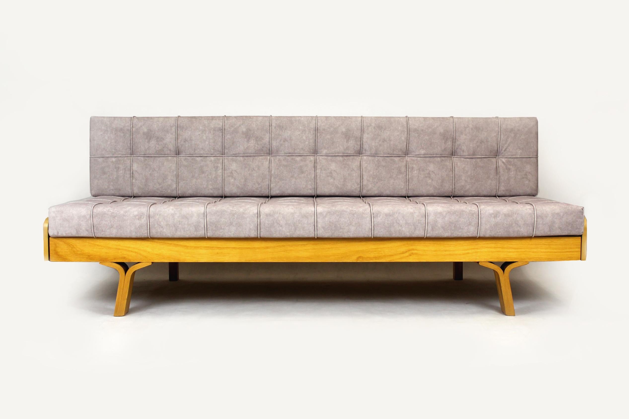 This Mid-Century Modern sofa was designed by Ludvik Volak and produced by Holesov in the 1960s in Czechoslovakia. The couch simply converts into a full-size bed: 196x157cm. 
The sofa has been restored, it has new cushions upholstered in