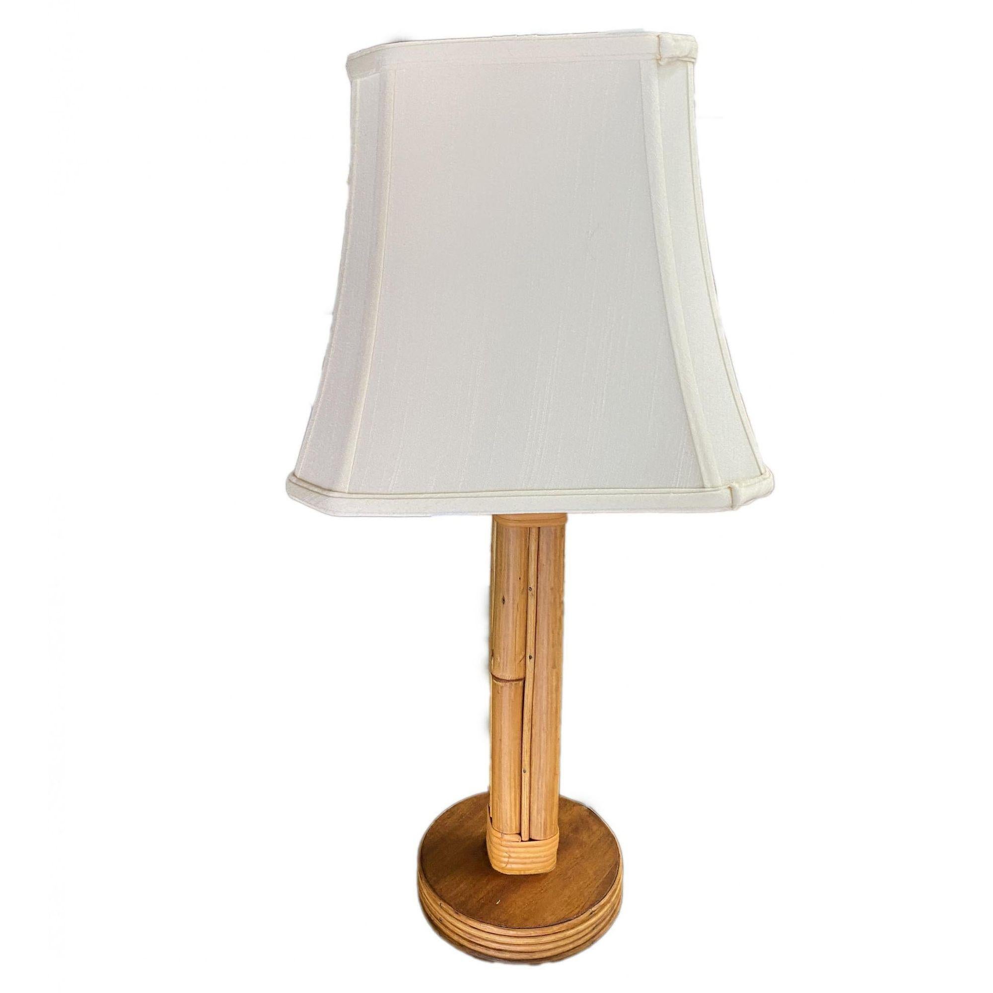 Restored pair of mid-century Paul T. Frankl inspired rattan table lamps featuring eight decorative rattan poles fixed to a round mahogany base with fancy wrappings, circa 1950.

Measure from bottom to top of socket: 19