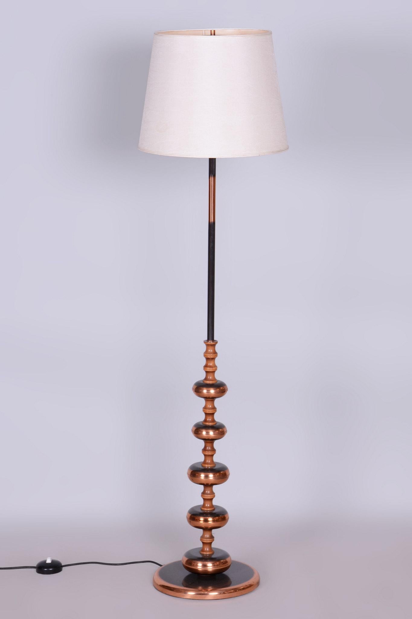 This elegant Mid-Century floor lamp comes from Germany from the 1960s. It is made of steel and copper and has a textile lampshade.

The lamp has undergone careful restoration, during which it was professionally cleaned and has new wiring. This