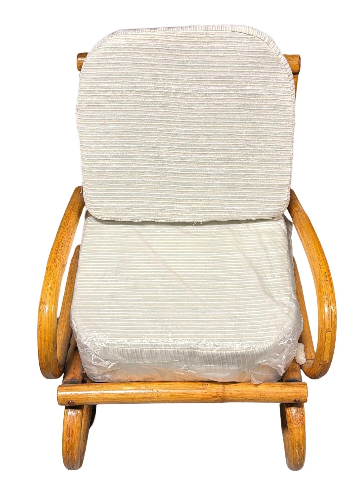 Ce fauteuil à bascule en rotin de taille enfant, magnifiquement restauré, allie le charme du vintage à la robustesse de l'artisanat. Le fauteuil est fabriqué à partir de bras et de pieds en rotin cintré à un seul brin, avec de grandes boucles