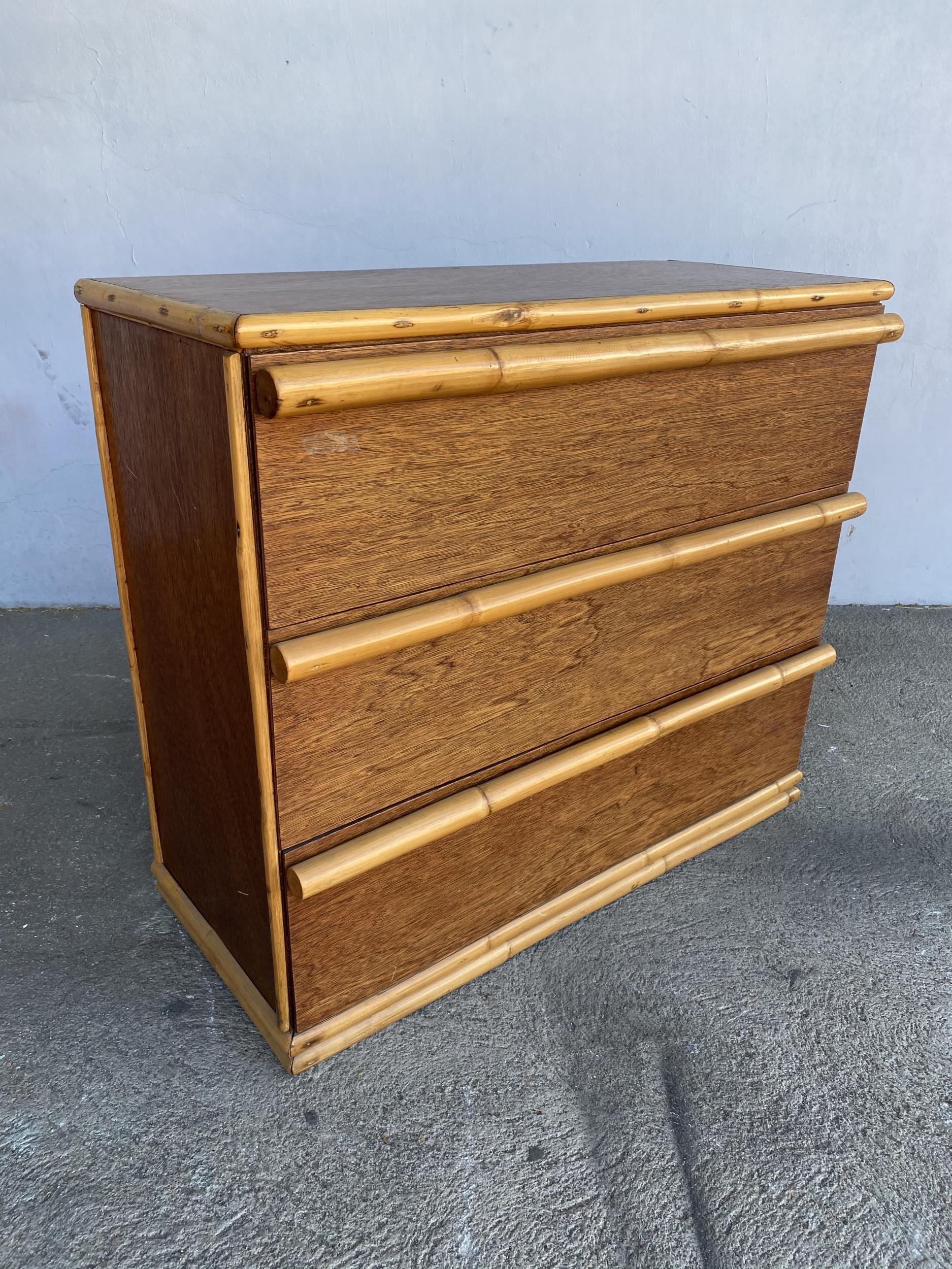 Restored Postwar mahogany lowboy dresser with large full-length rattan pulls along each drawer and stacked rattan base.

Restored to new for you.

All rattan, bamboo, and wicker furniture has been painstakingly refurbished to the highest