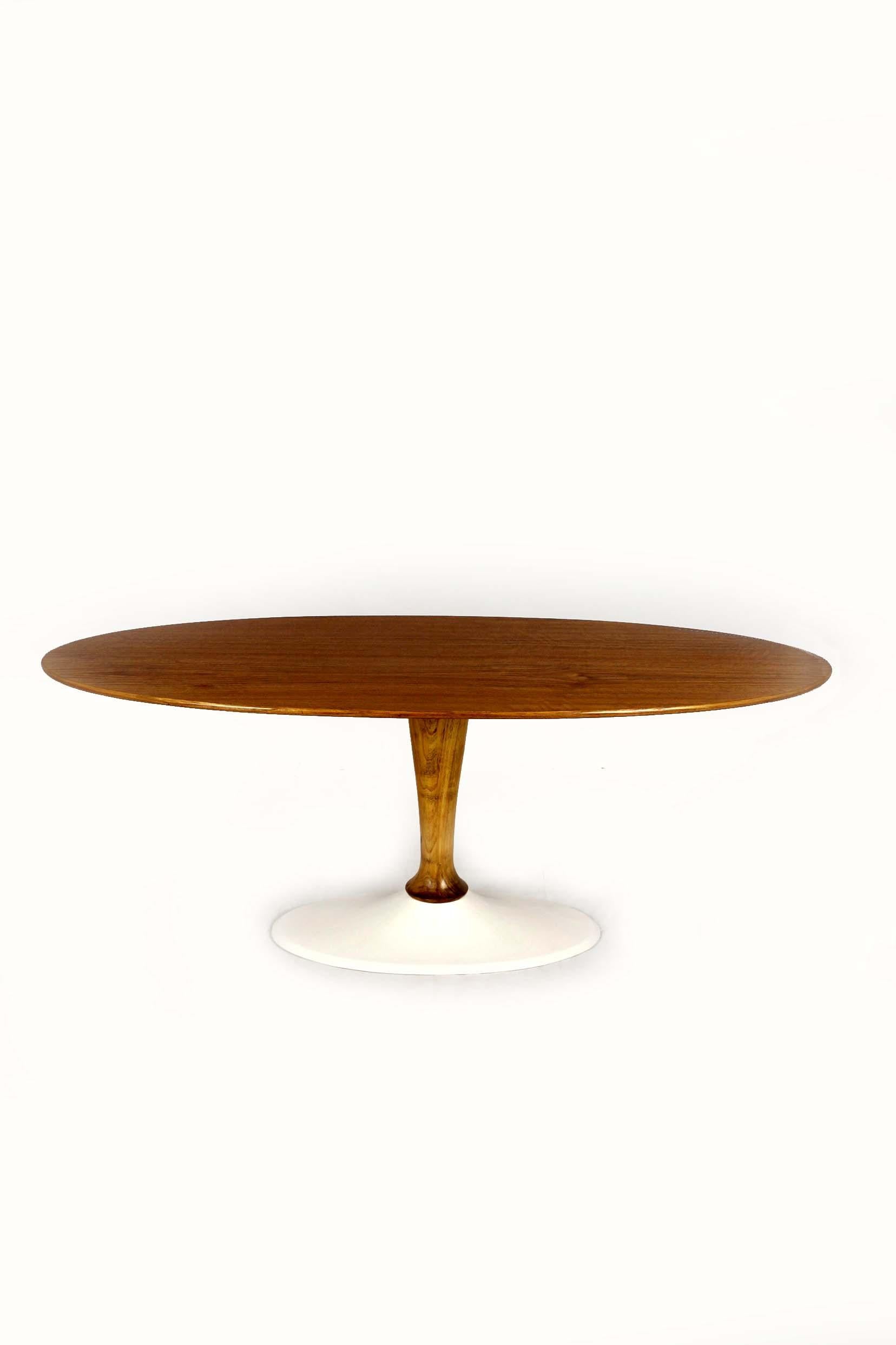 This elegant mid-century modern coffee table was manufactured by Drevotvar in former Czechoslovakia during the 1960s–70s. It features an oval walnut veneer top with a warm, expressive grain, supported by a sculptural turned wood column and a heavy,
