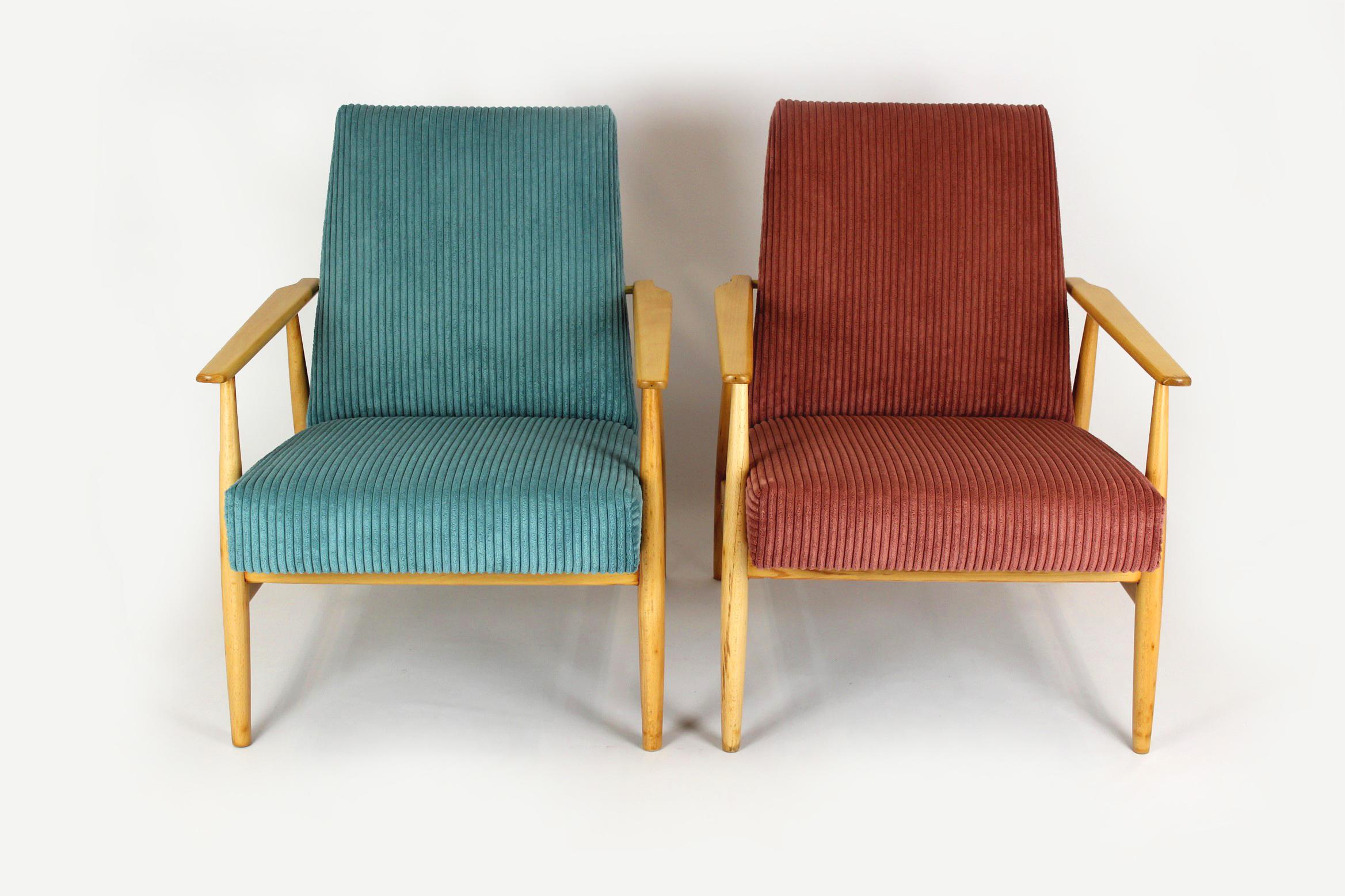 A pair of beechwood armchairs produced in the mid-1960s in Poland. These armchairs have been completely restored. The wood has been lacquered in a satin finish. The seats have been renewed, upholstered in turquoise and pink fabric with increased