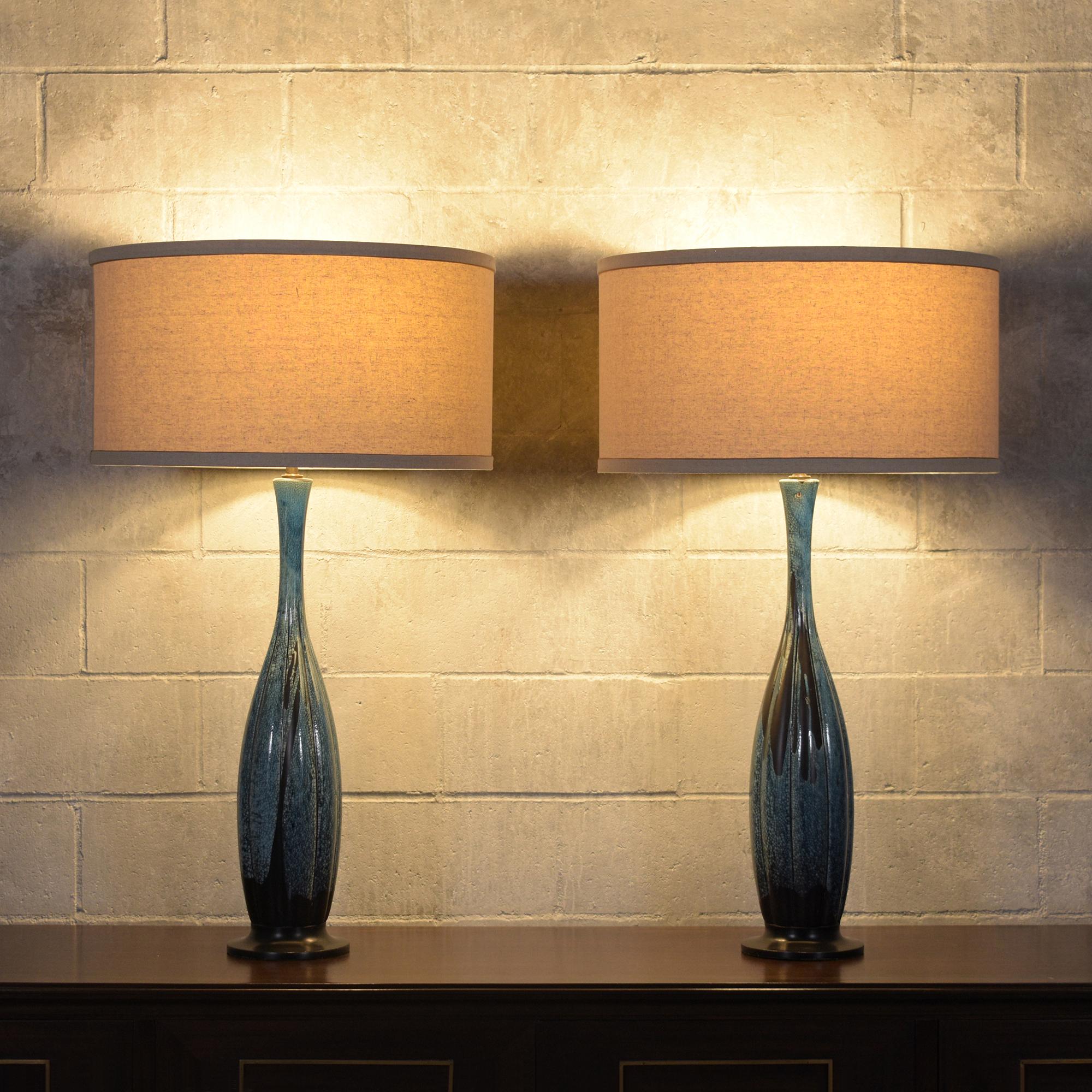 Elevate your space with our pair of mid-century table lamps, showcasing the unparalleled craftsmanship and iconic design of the era. These lamps, crafted from premium porcelain, have been meticulously restored to their original splendor, blending