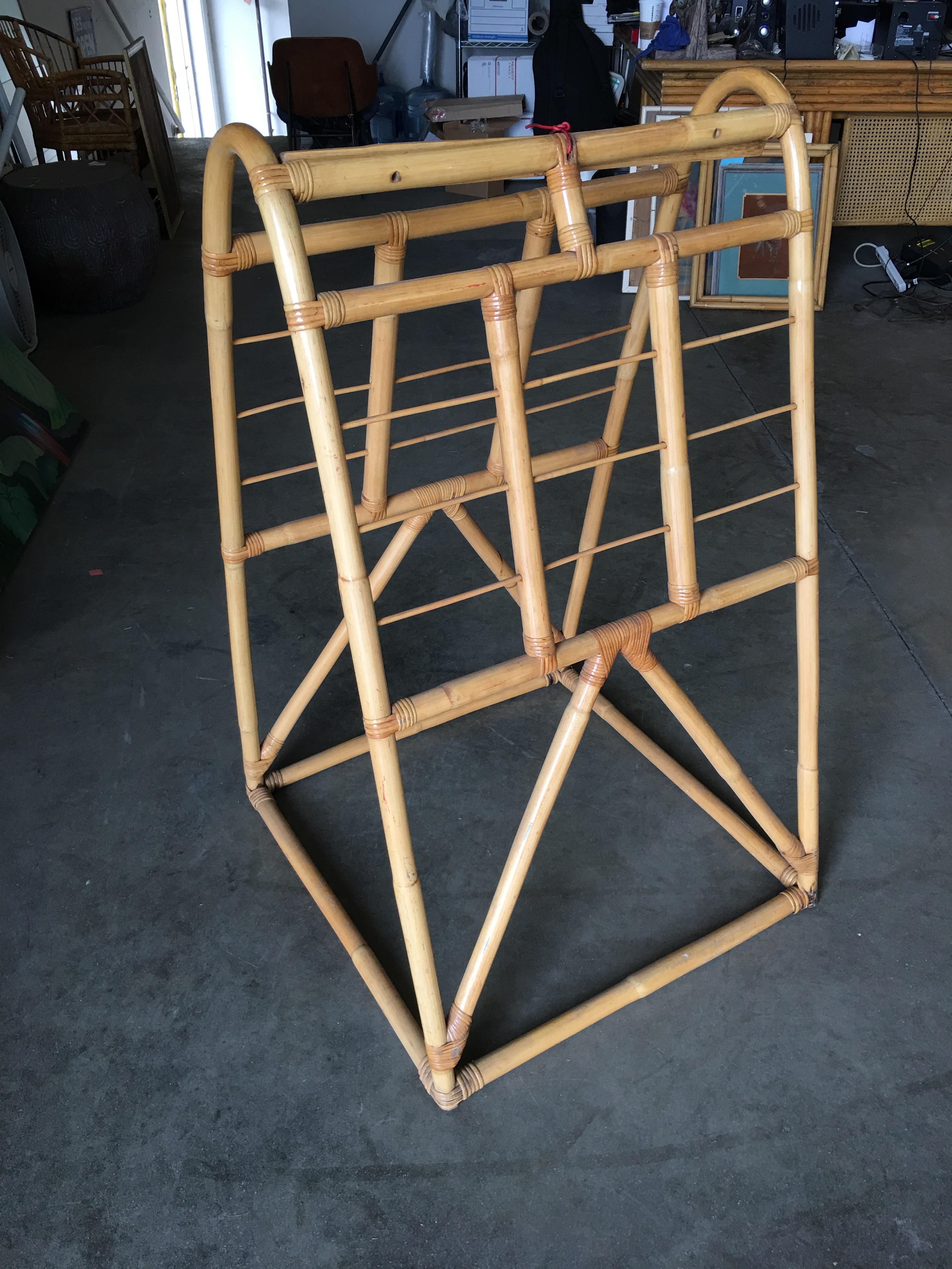 Circa 1950 rattan drying rack featuring an arch-shaped stand with 18 bars for drying your clothing and linens.

All pieces listed are professionally restored.  All our rattan, bamboo, and wicker furniture has been painstakingly refurbished to the