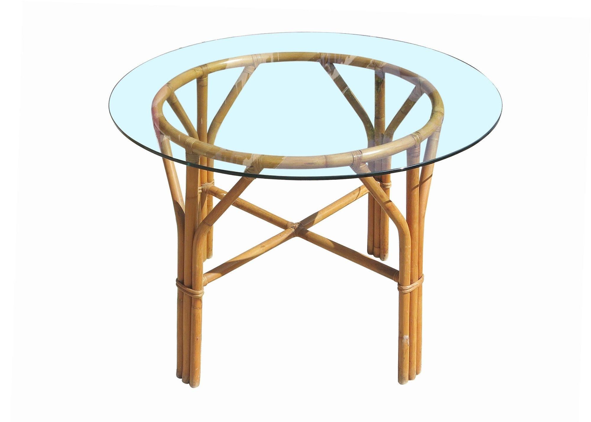 Mid-century rattan dining set featuring four dining chairs and dining table. This minimal, yet elegant dining table and chairs chair set features a steam pressed sculptural form with a round glass top for the table. This set can easily accommodate