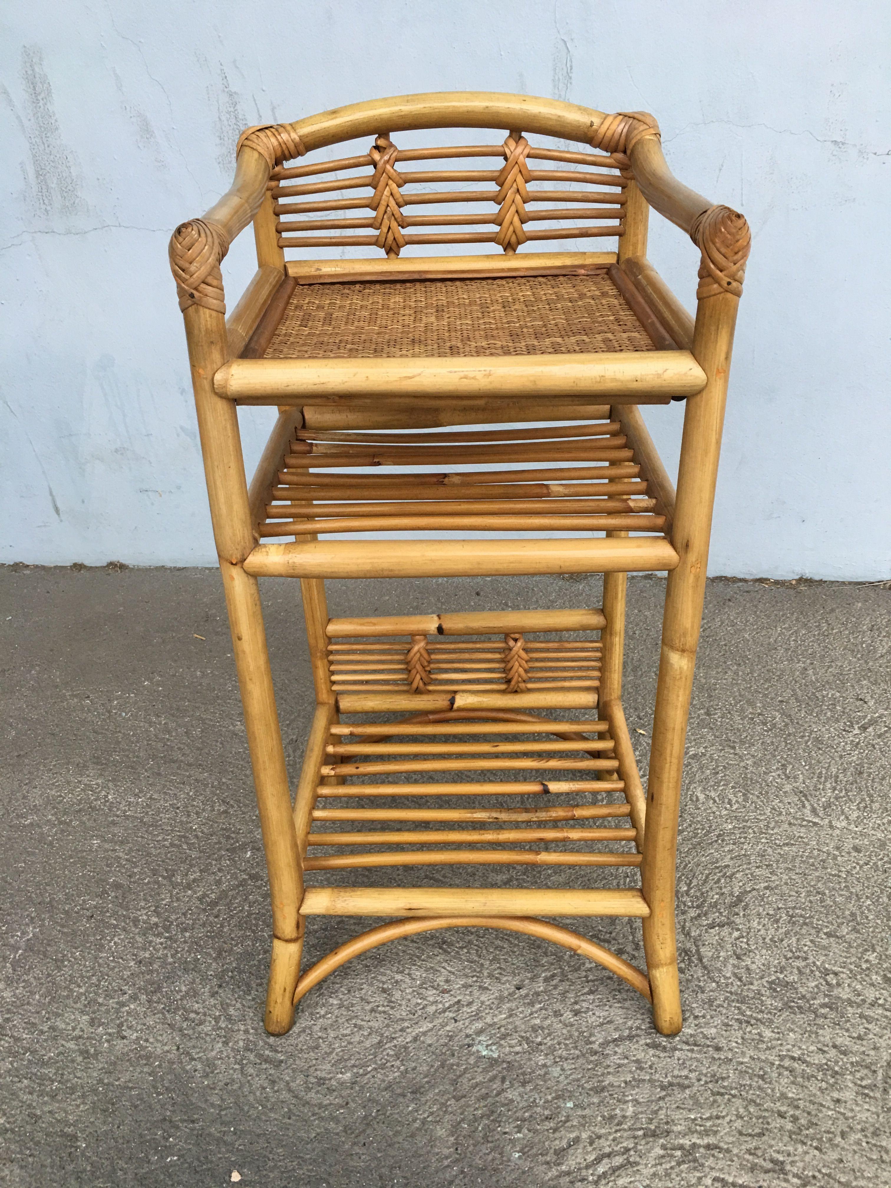Vintage three-level rattan book self with hand-woven rice mat shelf on top and decorative stick rattan backplate along the top and bottom to display a decorative object such as a vase or statue. Restored to new for you. All rattan, bamboo and wicker