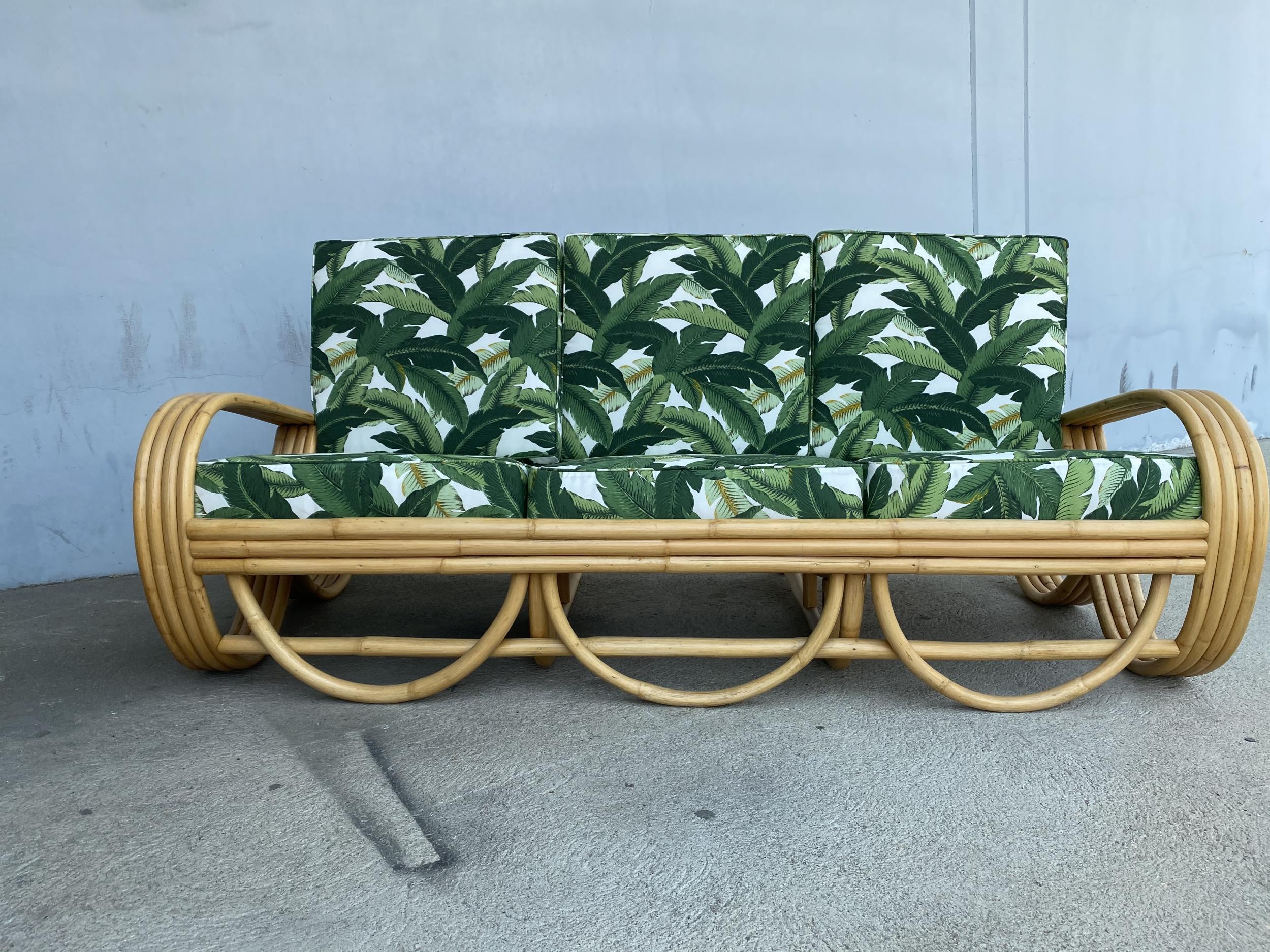 Four-strand 3/4 reverse pretzel rattan sofa and four strand lounge chair set both featuring a decorative wave detail on the base. 

Reminiscent of the sofas done by Paul Frankl in the 1940s.

Sofa: 28
