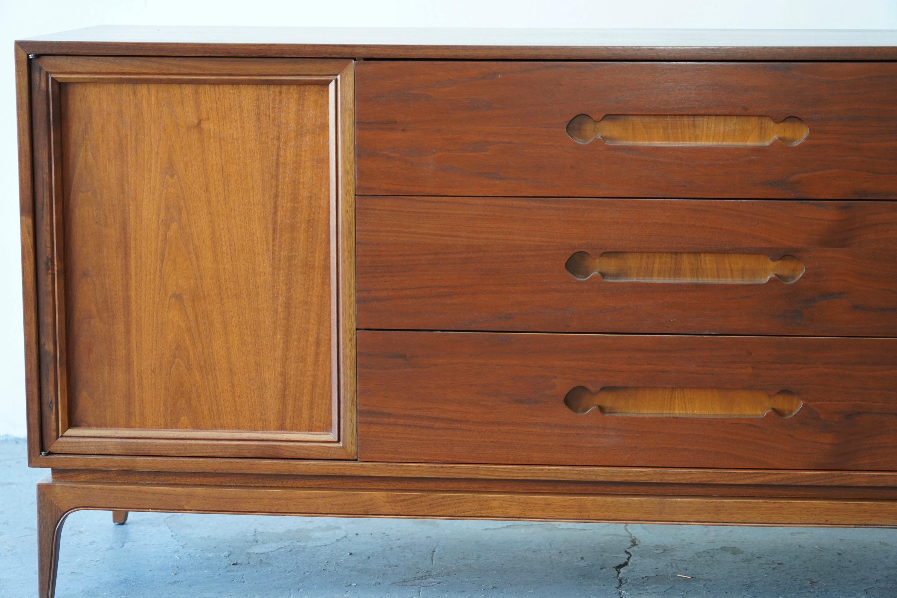 This is a mid century modern low dresser credenza from Kent Coffey’s Tableau collection . It has nine dovetailed drawers with a streamlined design, cool pulls, and with tapered legs. 
Note we call this the Sahara dresser. because we are based here