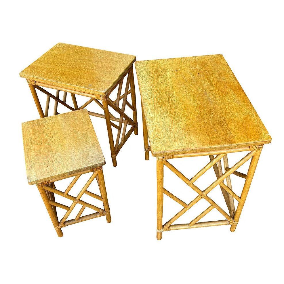 This beautifully restored Paul Frankl-inspired set of 3 Rattan nesting tables with inset mahogany tabletops. The Rattan used for these nesting tables was imported from the Philippines and assembled in the United States, as is typical of high-end