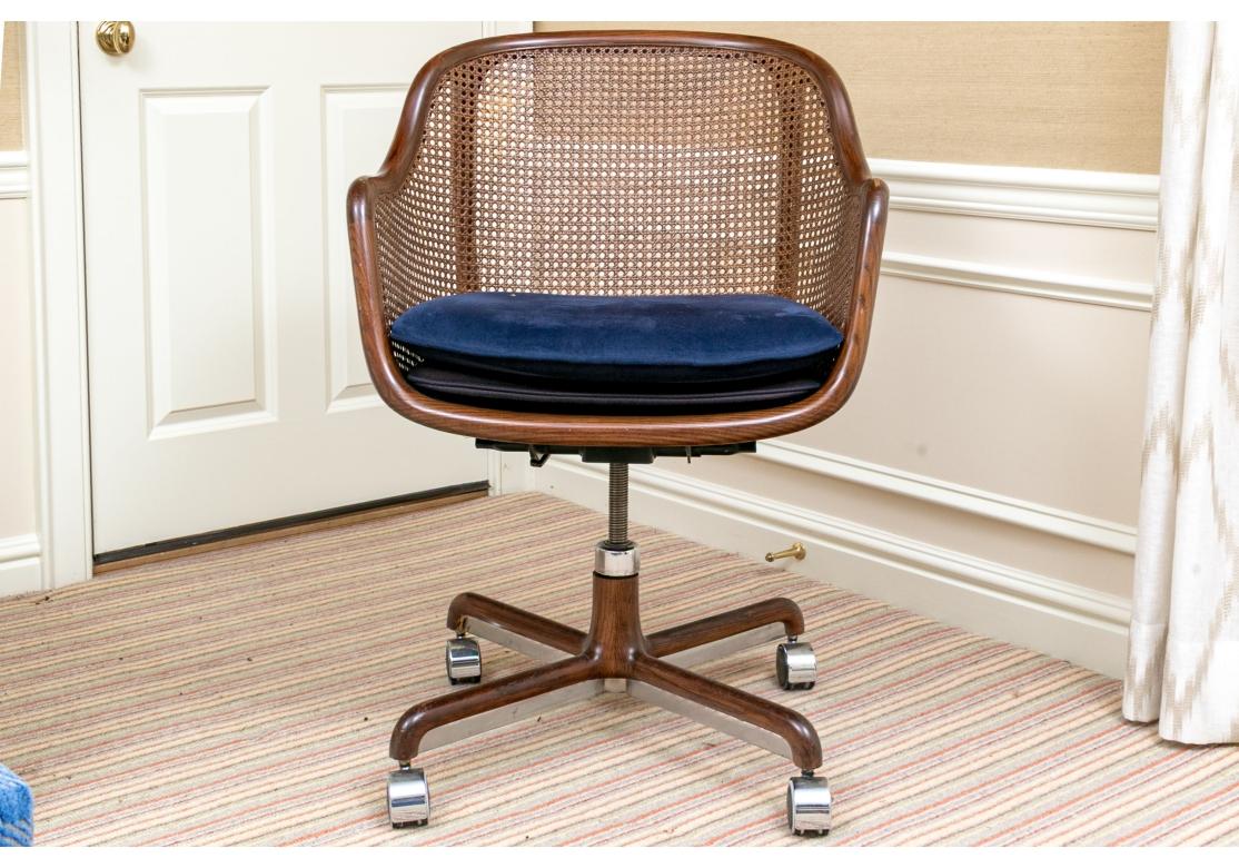 Das unglaubliche Design aus den 1960er Jahren mit einem Rahmen aus massiver Esche, gebeizt in einer tiefen Nussbaumbeize, die die Holzmaserung hervorragend zur Geltung bringt. Mit durchgehenden Cane Panel-Seiten und -Rücken, verstellbarer Höhe und