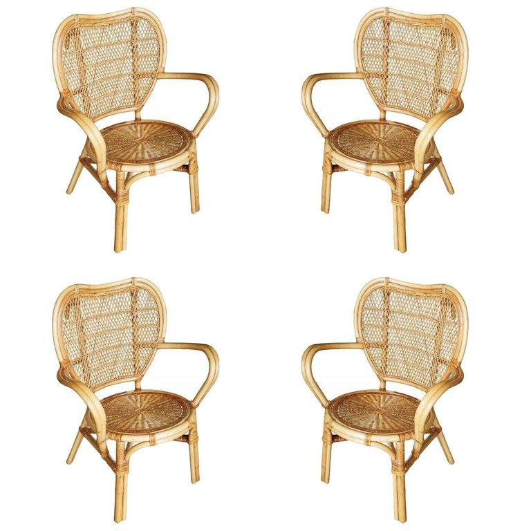 Vintage rattan and wicker dining room chair, included is a set of four chairs. Each chair features a woven wicker seat and back seat with large free-form bent arms. 

Restored to new for you.

All rattan, bamboo and wicker furniture has been