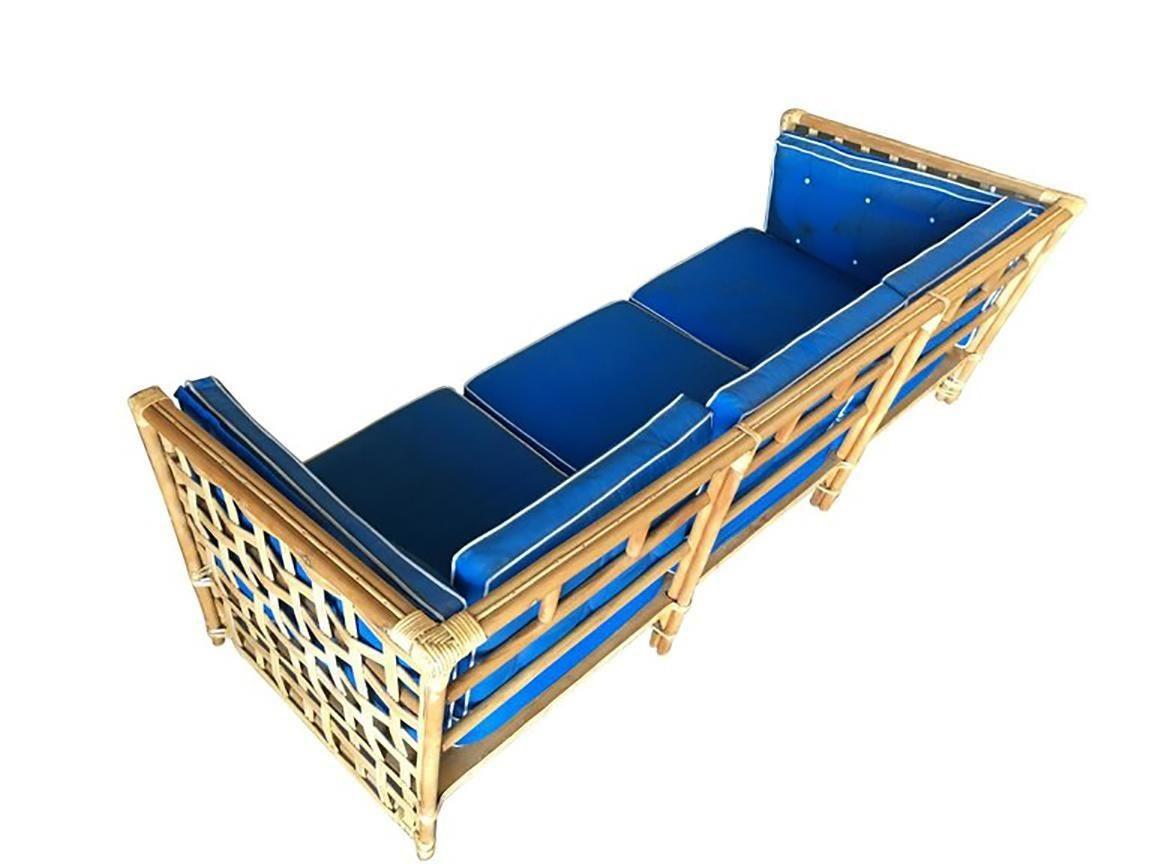 Mid-Century Baughman style rattan sofa with woven stick rattan sides and pole rattan frame. The seats are covered in tuft blue cloth cushions.

1950, United States

Sofa: 34