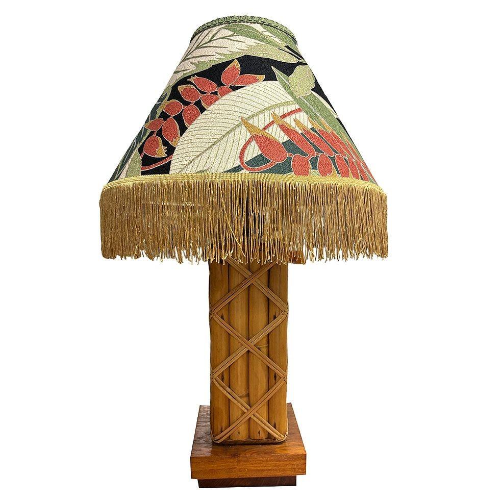 This beautifully restored Paul Frankl-inspired Mid-century rattan table lamp is adorned with intricate lattice wrappings, bringing a unique rustic tropical modernist piece. The lamp comes with a period lampshade that complements the earthy texture