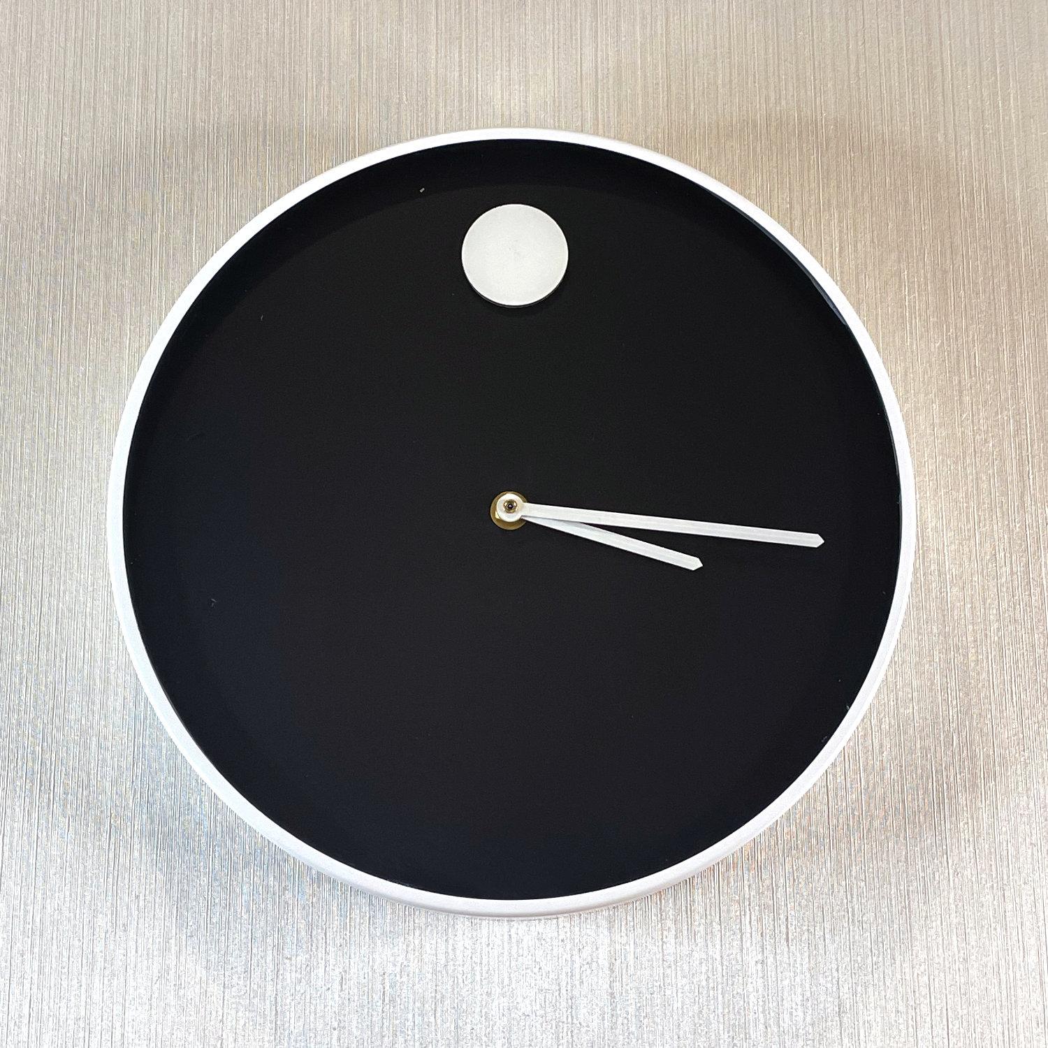Exquisitely restored Nathan George Horwitt Museum Clock. The clock was produced by Howard Miller of Zeeland, Michigan. The Avant-Garde Modernist design features a black face with a single white circle indicating the 12 position. Two white hands