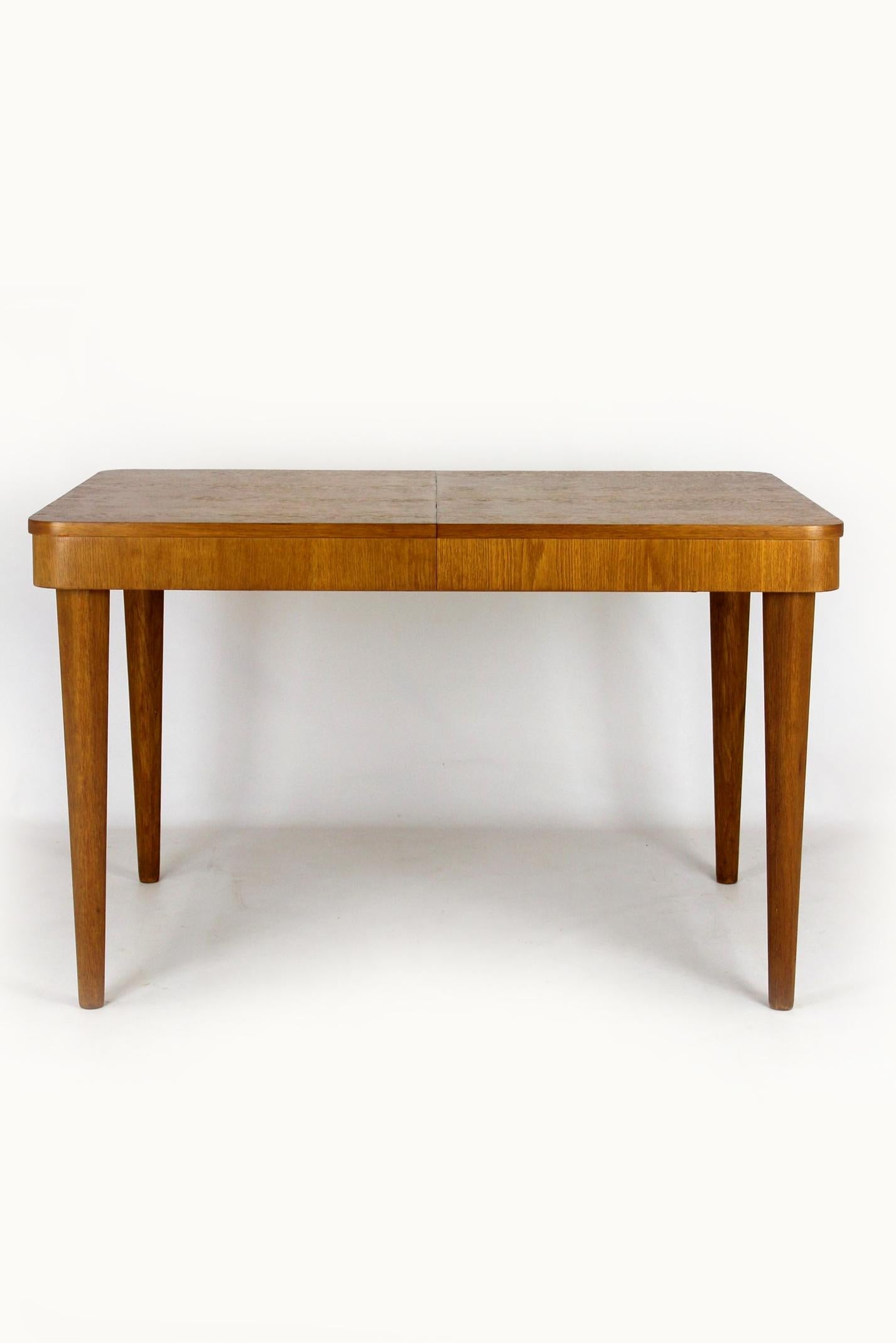 This extendable dining table was designed by Jindrich Halabala and manufactured in the Czech Republic in the 1950s. Thanks to a specially designed mechanism of steel cables and guides, the table can be unfolded by one person in a few moments. The