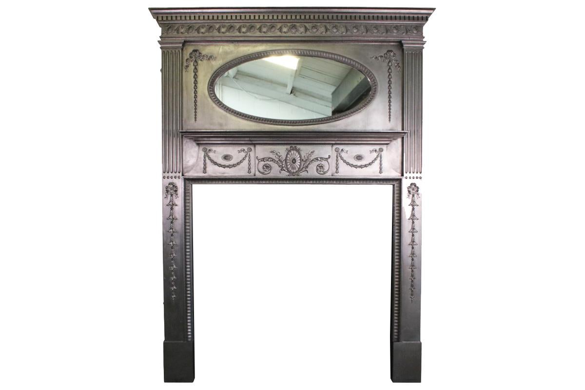 Restored original antique Edwardian tall cast iron fireplace surround with an oval mirror to the deep freize above a secondary mantle shelf and classical detail cast to the lower frieze and pillars. 

Pictured with an original cast iron and tiled