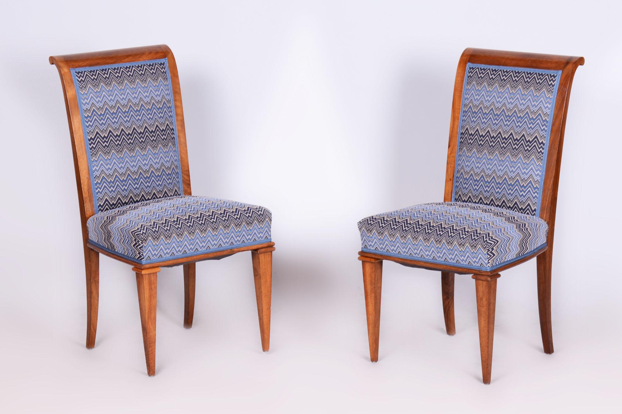 Wir stellen ein elegantes Paar Art-Déco-Stühle aus der ersten Hälfte des 20. Jahrhunderts vor, die aus Frankreich stammen und von dem berühmten Architekten Jules Leleu entworfen wurden. Die Stühle sind aus massivem Walnussholz gefertigt und wurden