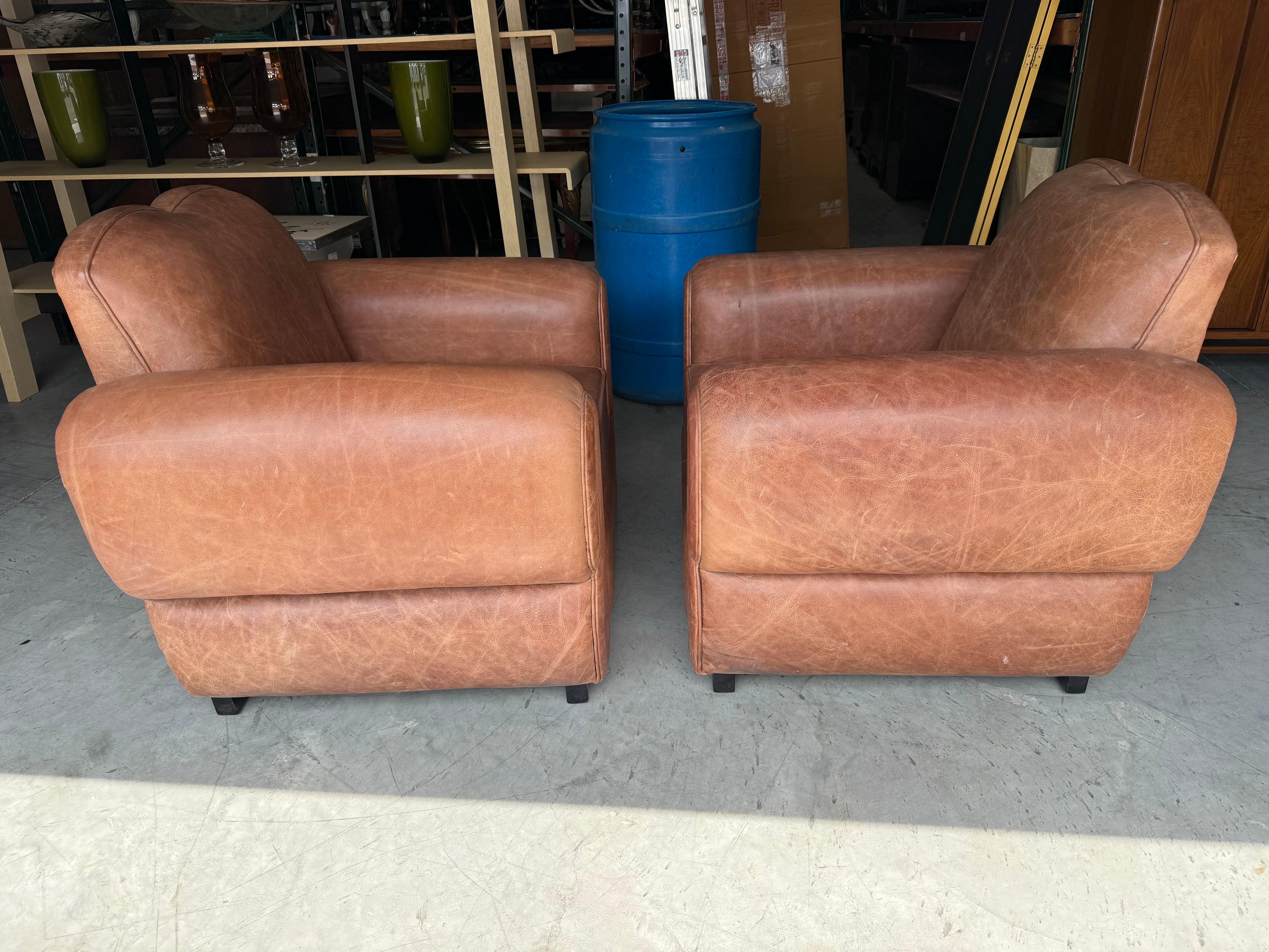 Offered here is a pair of restored French 1930s era Mustache Cigar Club Chairs, also known as Art Deco club chairs, showcasing the iconic curved “mustache” back design and sleek Deco-era proportions. Measuring 38 inches wide x 32 inches deep x 33.5