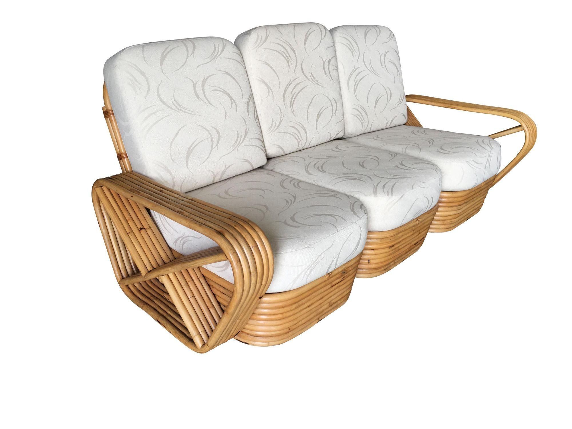 Paul Frankl style rattan living room set including a matching three-seat sectional sofa, and pair of end tables. The sofa features the famous six strand square pretzel side arms and stacked rattan base with matching stacked rattan side tables (pair)