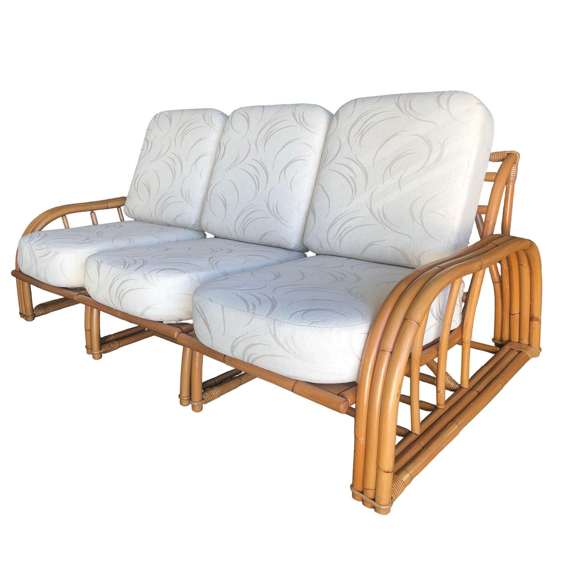 This restored Paul László rattan sectional three-seat sofa features a sleek, minimalist design that blends natural rattan with three-strand staple-shaped arms and open bases. The sectional layout offers clean lines and modernist appeal making it a