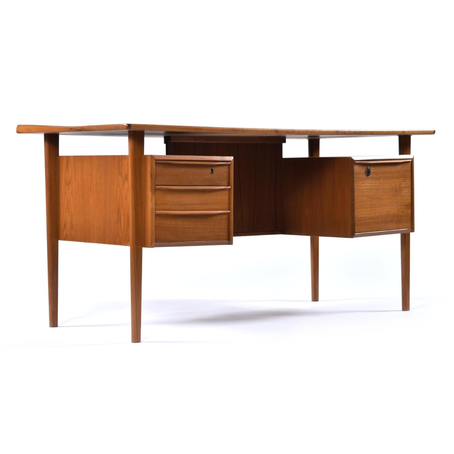 Mid-Century Modern Danish teak desk designed by Peter Lovig for Hedensted. This Scandinavian marvel has been fully restored. The desk top, cabinet, legs, have all been refinished. The desk even boasts new locking mechanisms on the drawers (key